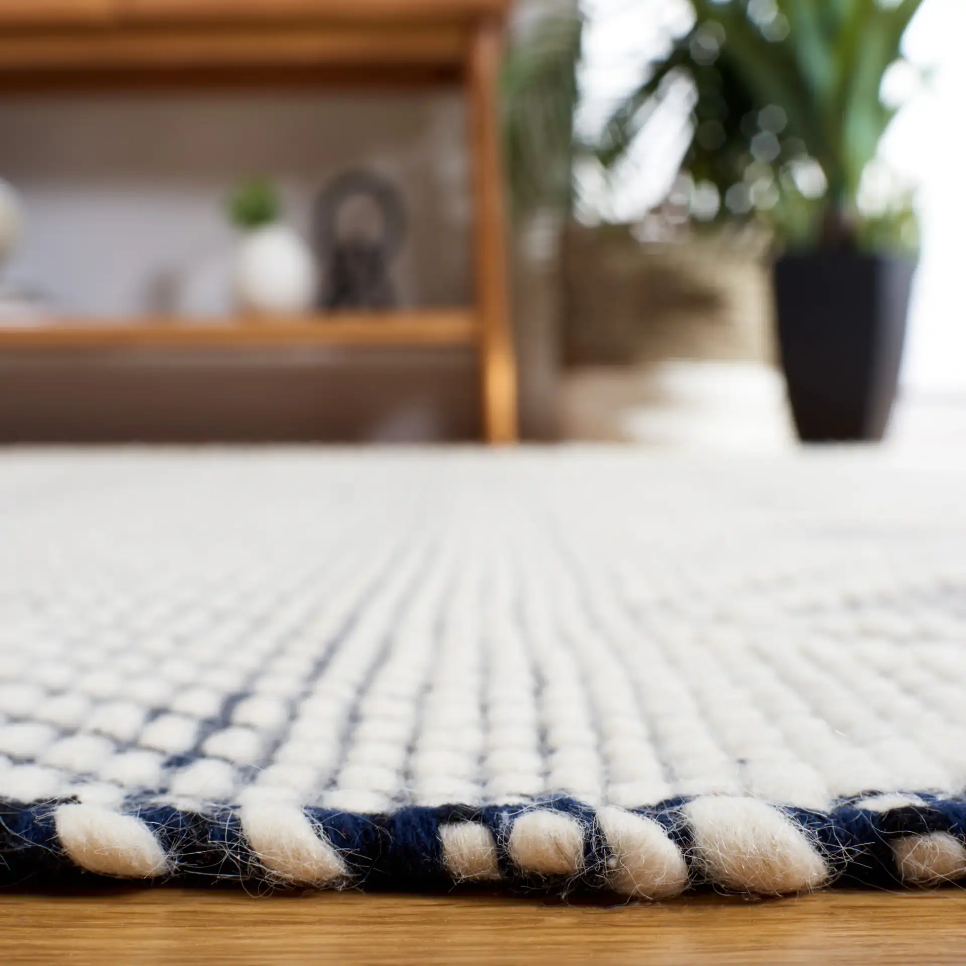Natura Banded Lozenge Geometric Hand-Woven Wool Rug in Ivory / Navy in a styled room