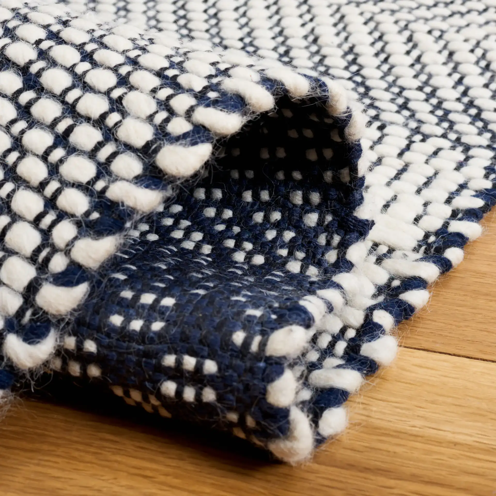 Natura Banded Lozenge Geometric Hand-Woven Wool Rug in Ivory / Navy in a styled room
