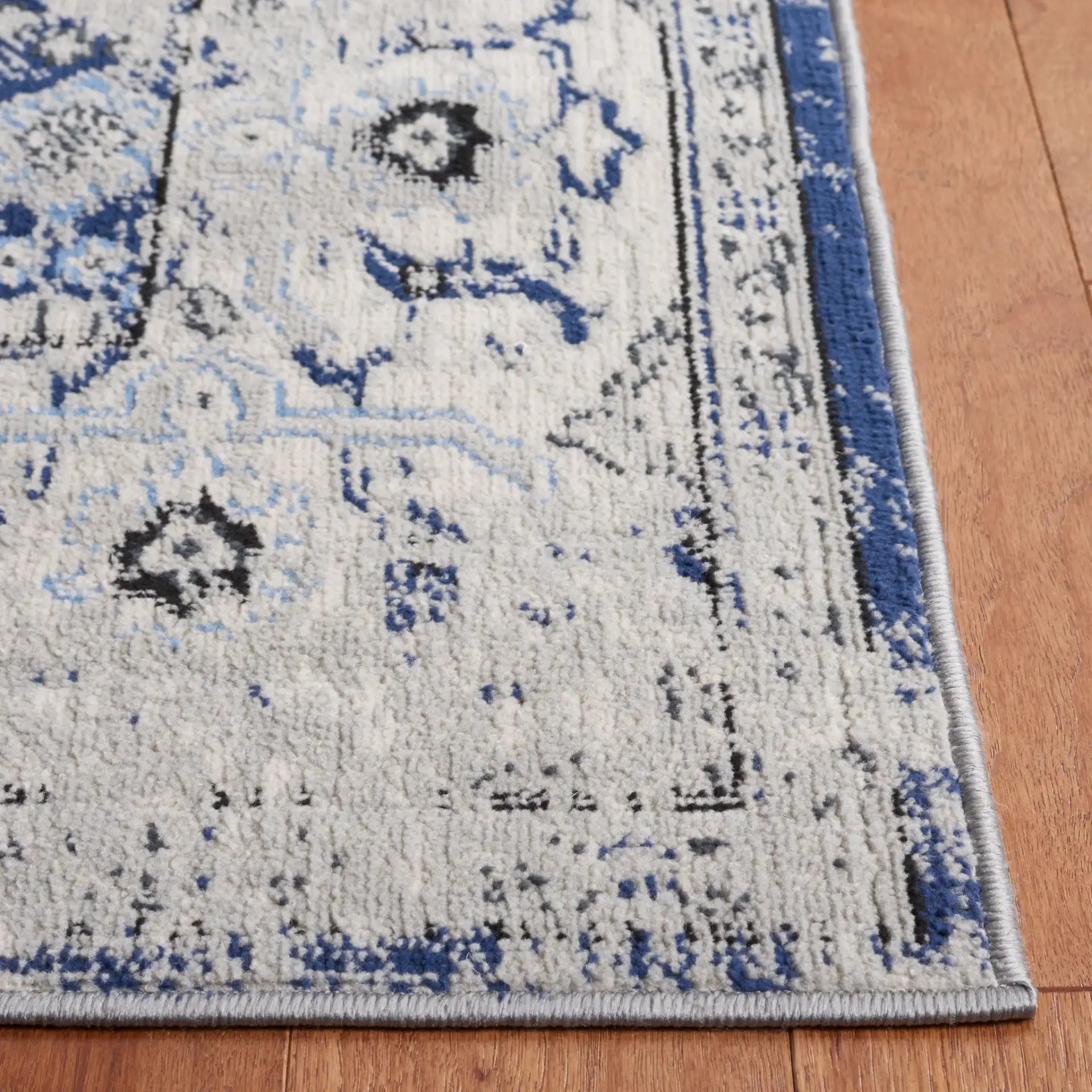Odyssey Distressed Floral Border Rug in Gray / Navy in a styled room