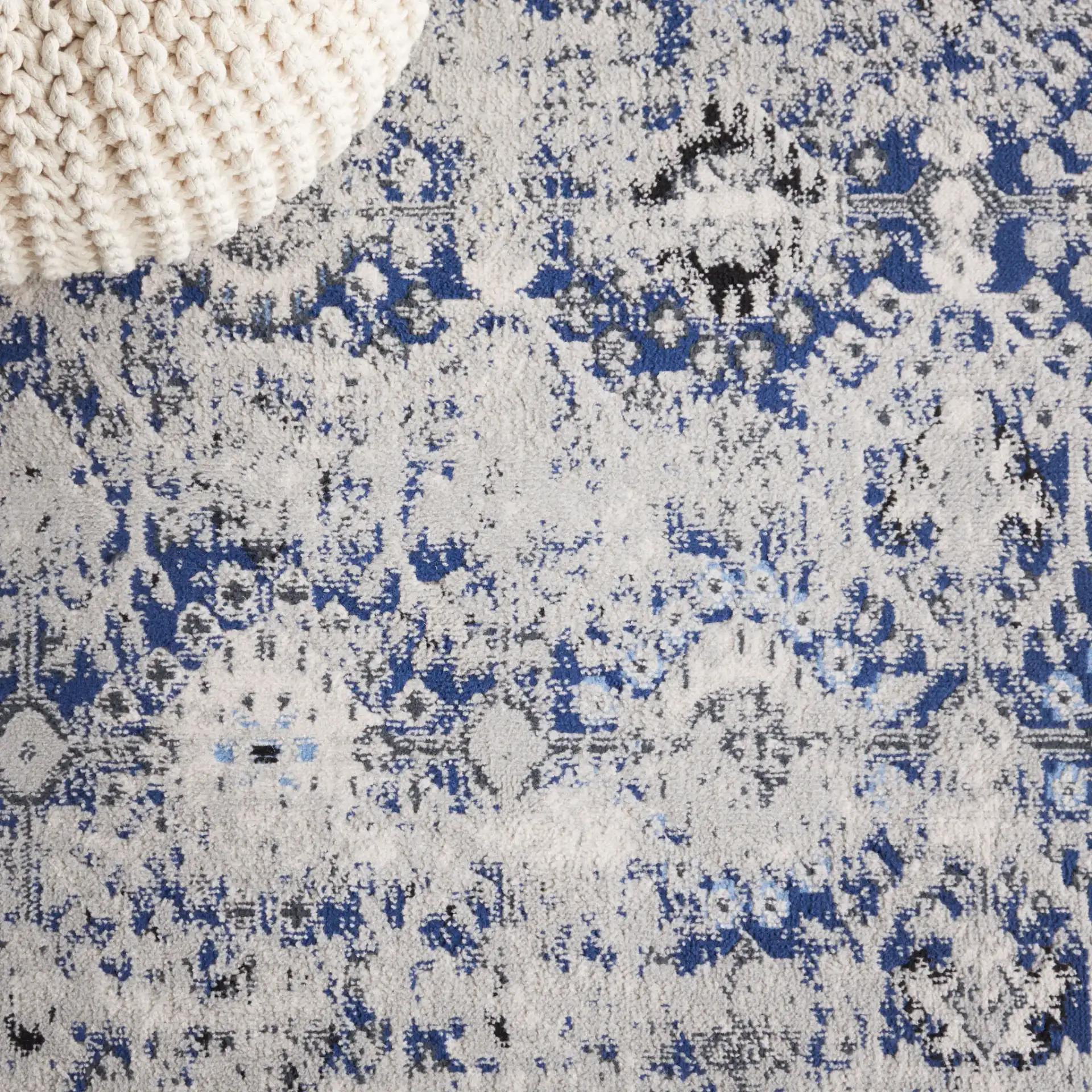 Odyssey Distressed Floral Border Rug in Gray / Navy in a styled room