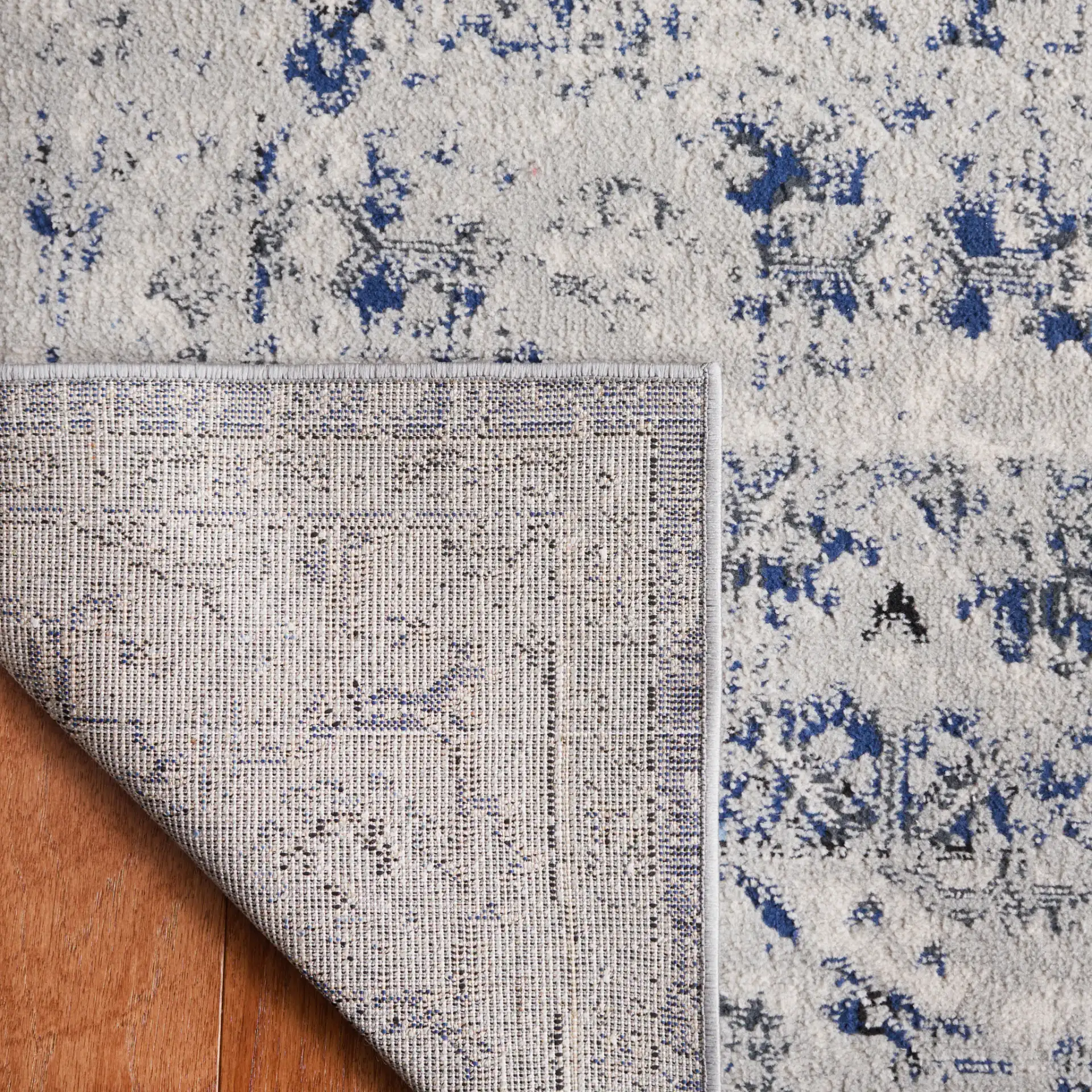 Odyssey Distressed Floral Border Rug in Gray / Navy in a styled room
