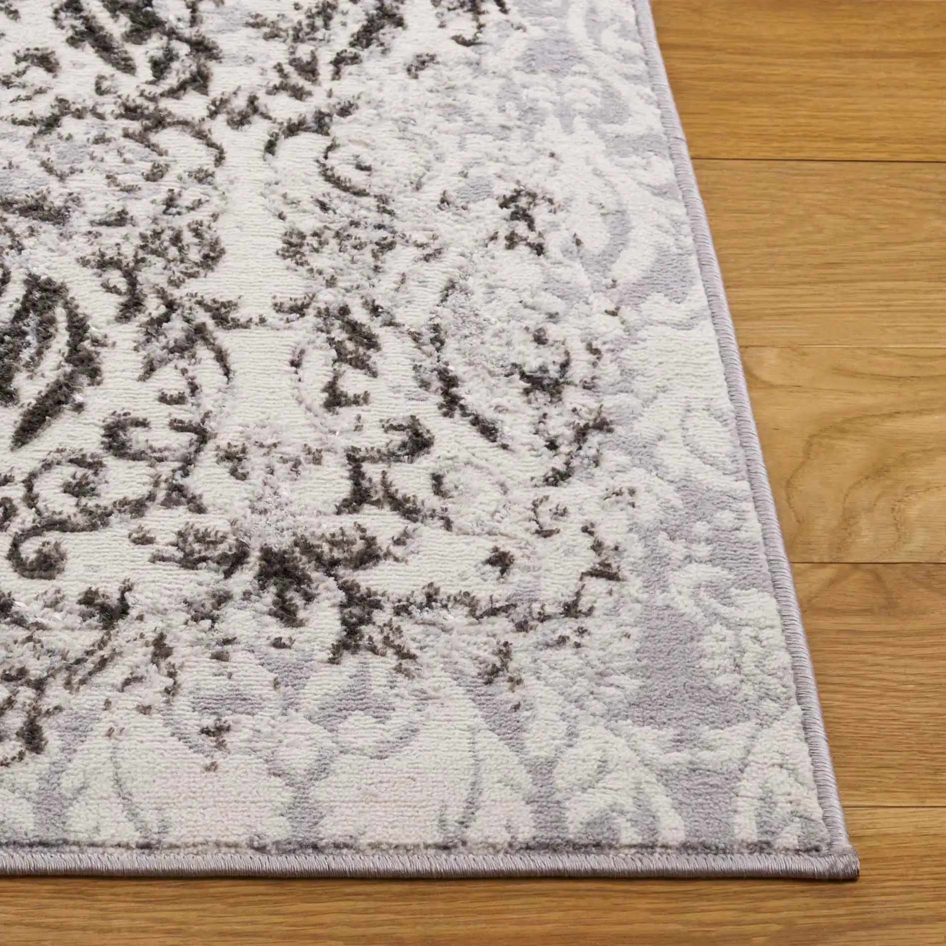 Orchard Distressed Damask Rug in Gray / Silver in a styled room