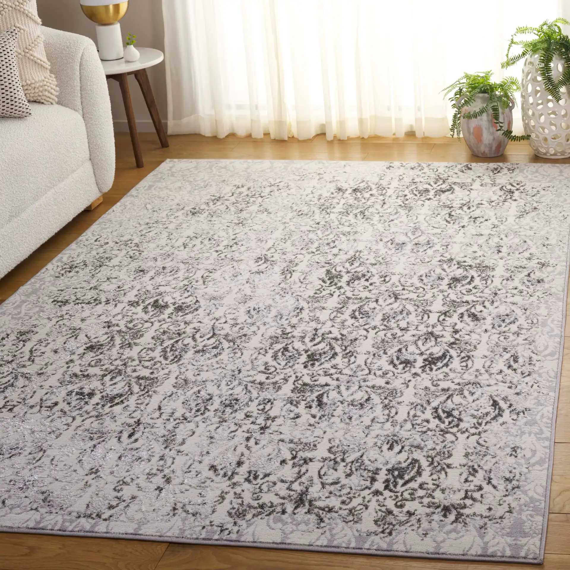 Orchard Distressed Damask Rug in Gray / Silver in a styled room