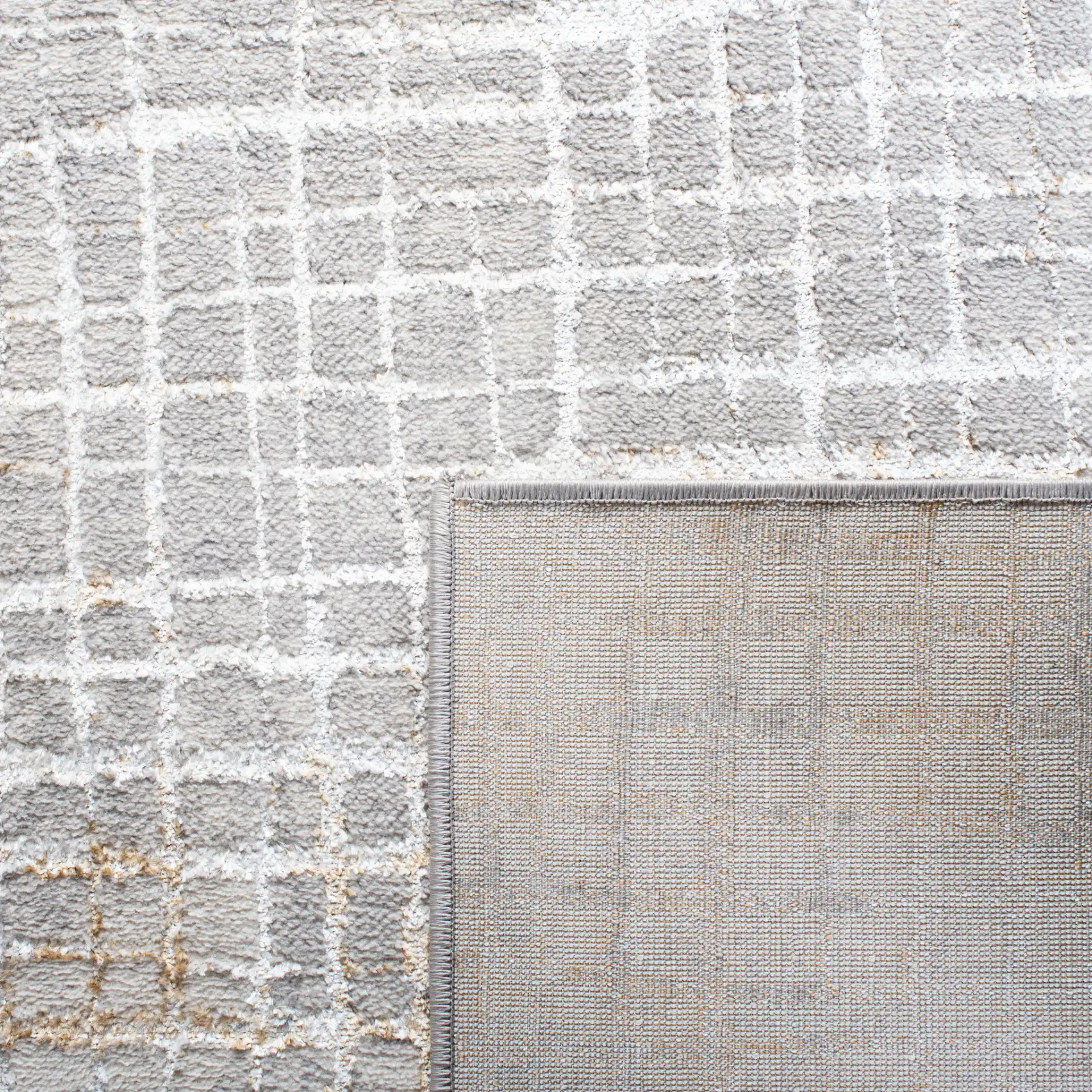 Orchard Abstract Grid Rug in Gray / Gold in a styled room