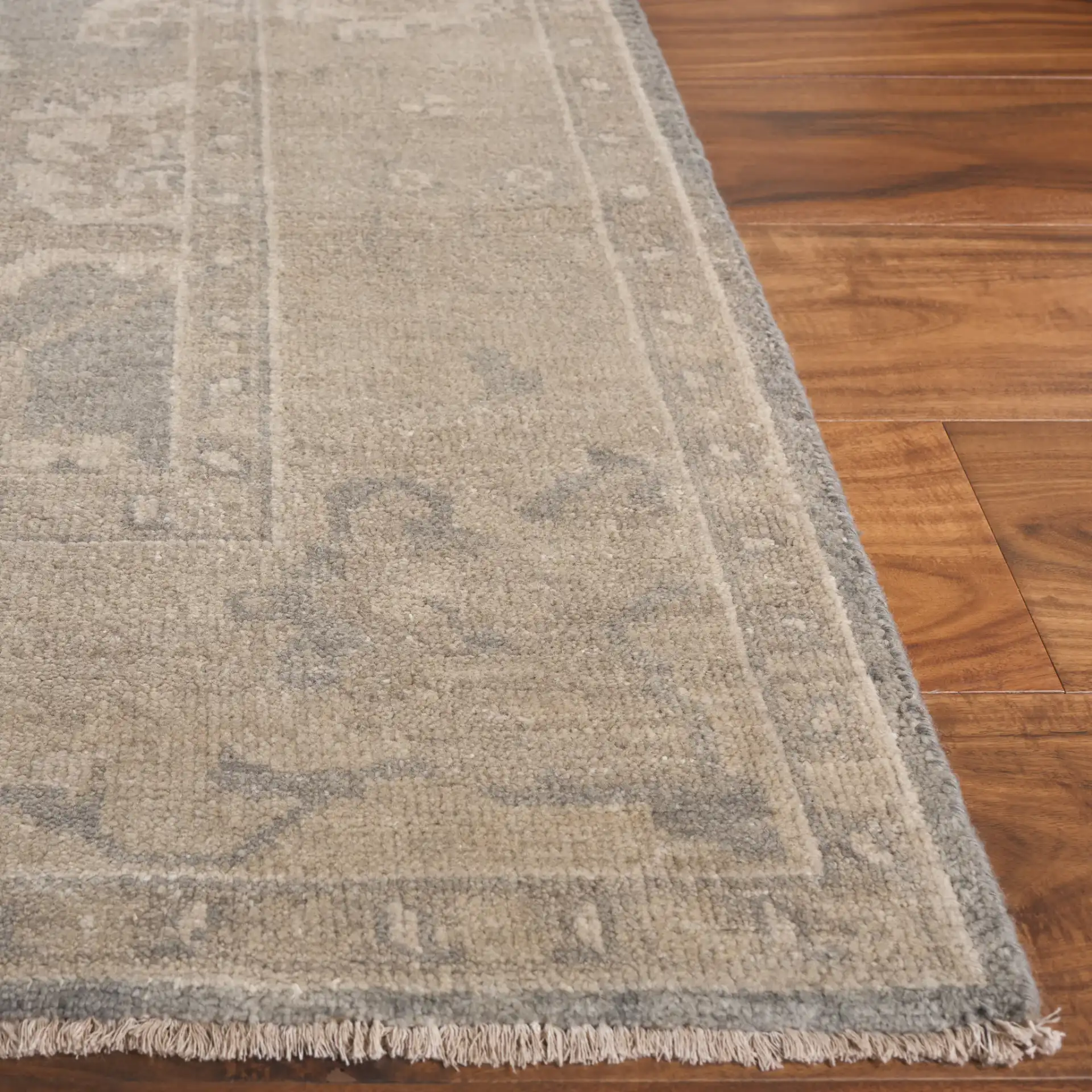 Oushak Faded Floral Bordered Hand-Knotted Wool Rug in Light Gray / Beige in a styled room