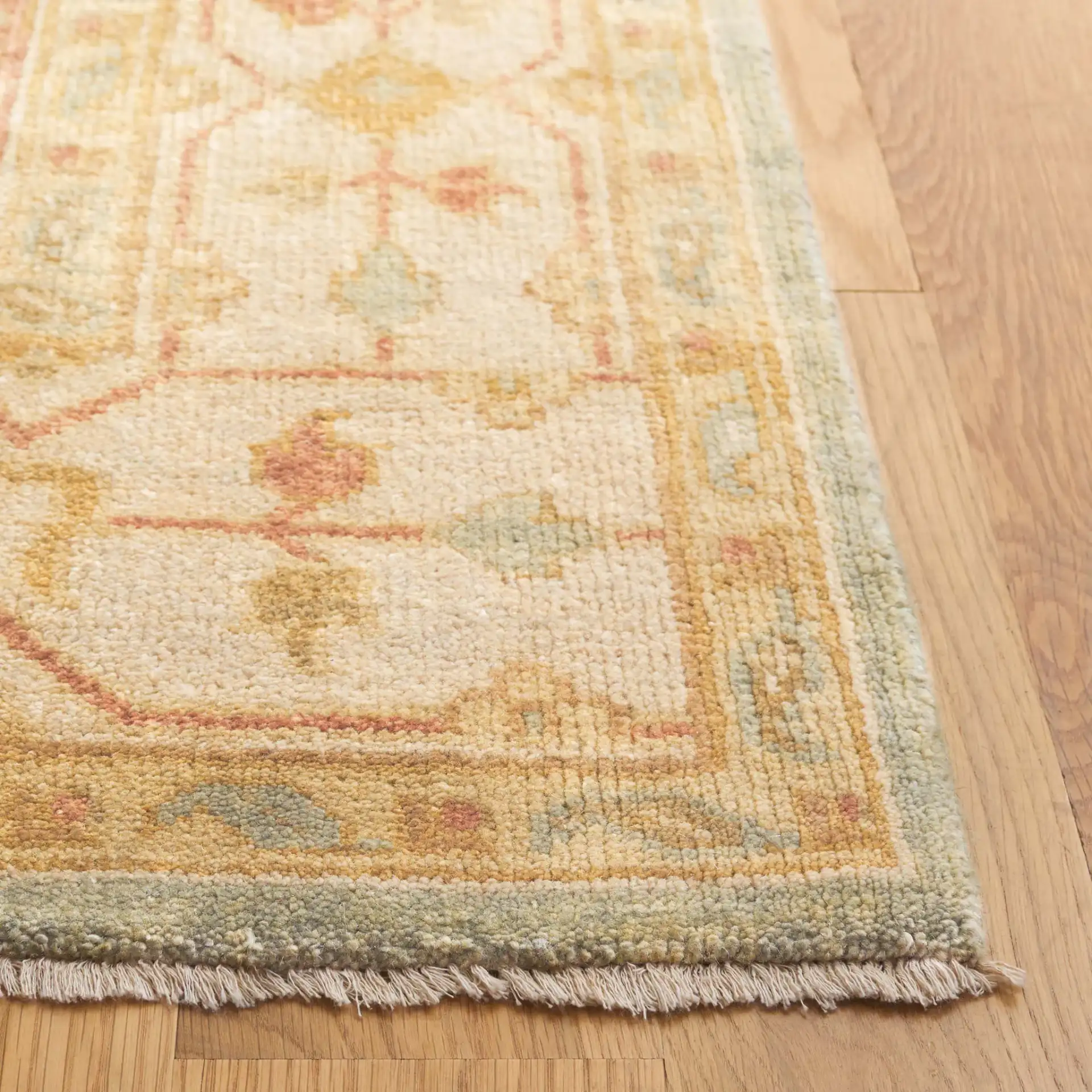 Oushak Scattered Blossom Hand-Knotted Wool Rug in Soft Green / Ivory in a styled room