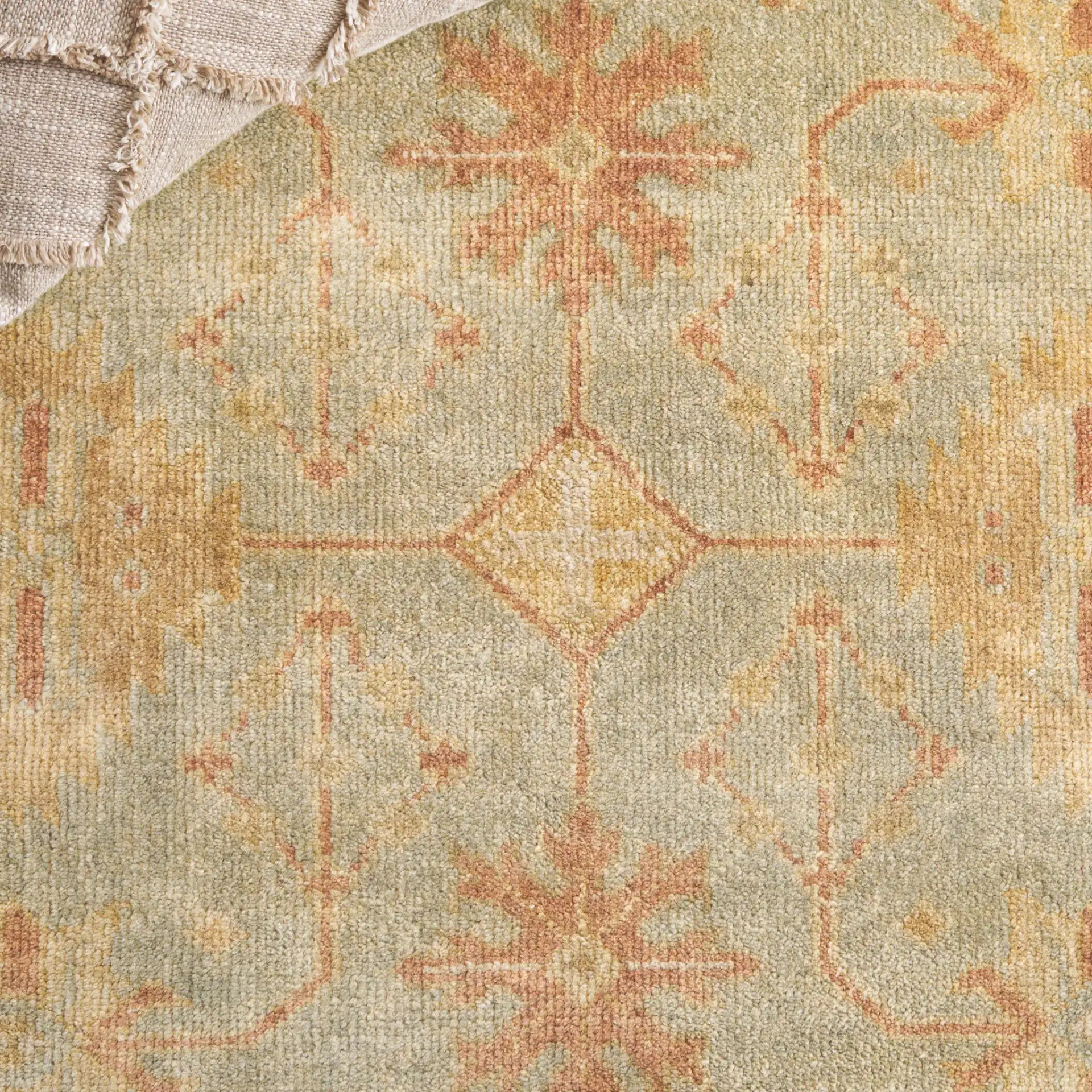 Oushak Scattered Blossom Hand-Knotted Wool Rug in Soft Green / Ivory in a styled room