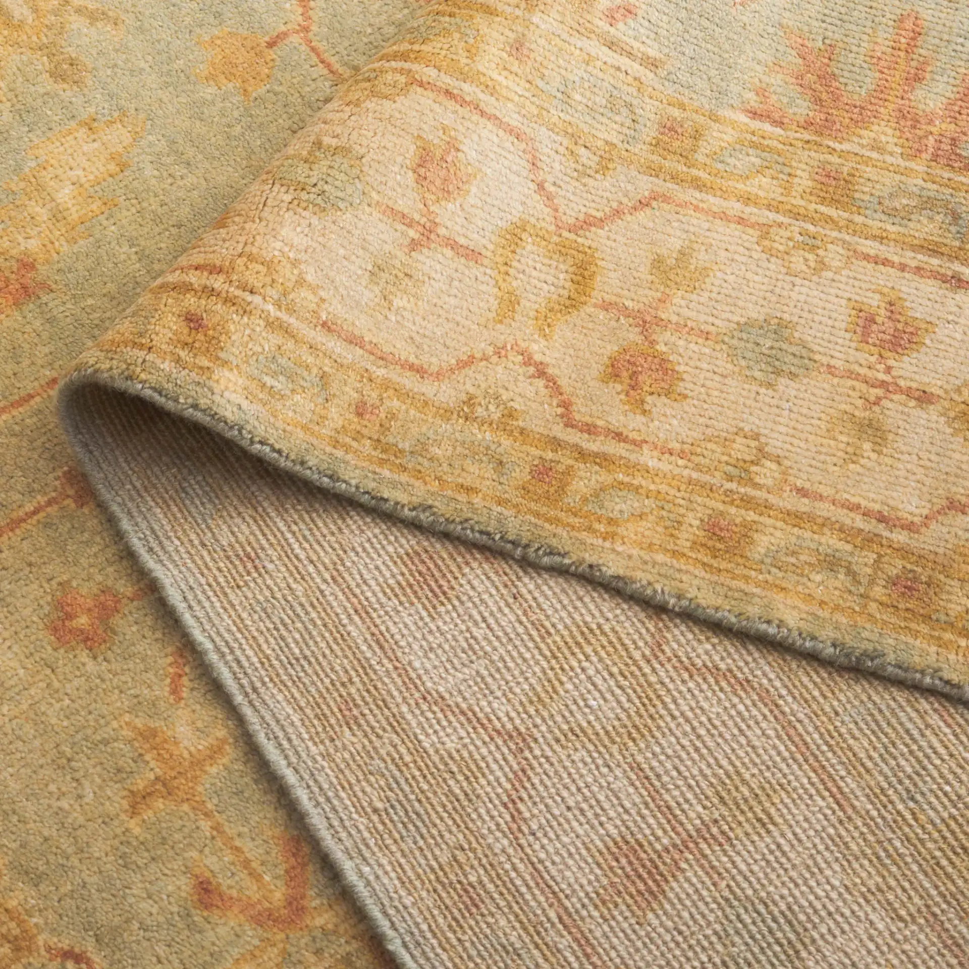 Oushak Scattered Blossom Hand-Knotted Wool Rug in Soft Green / Ivory in a styled room