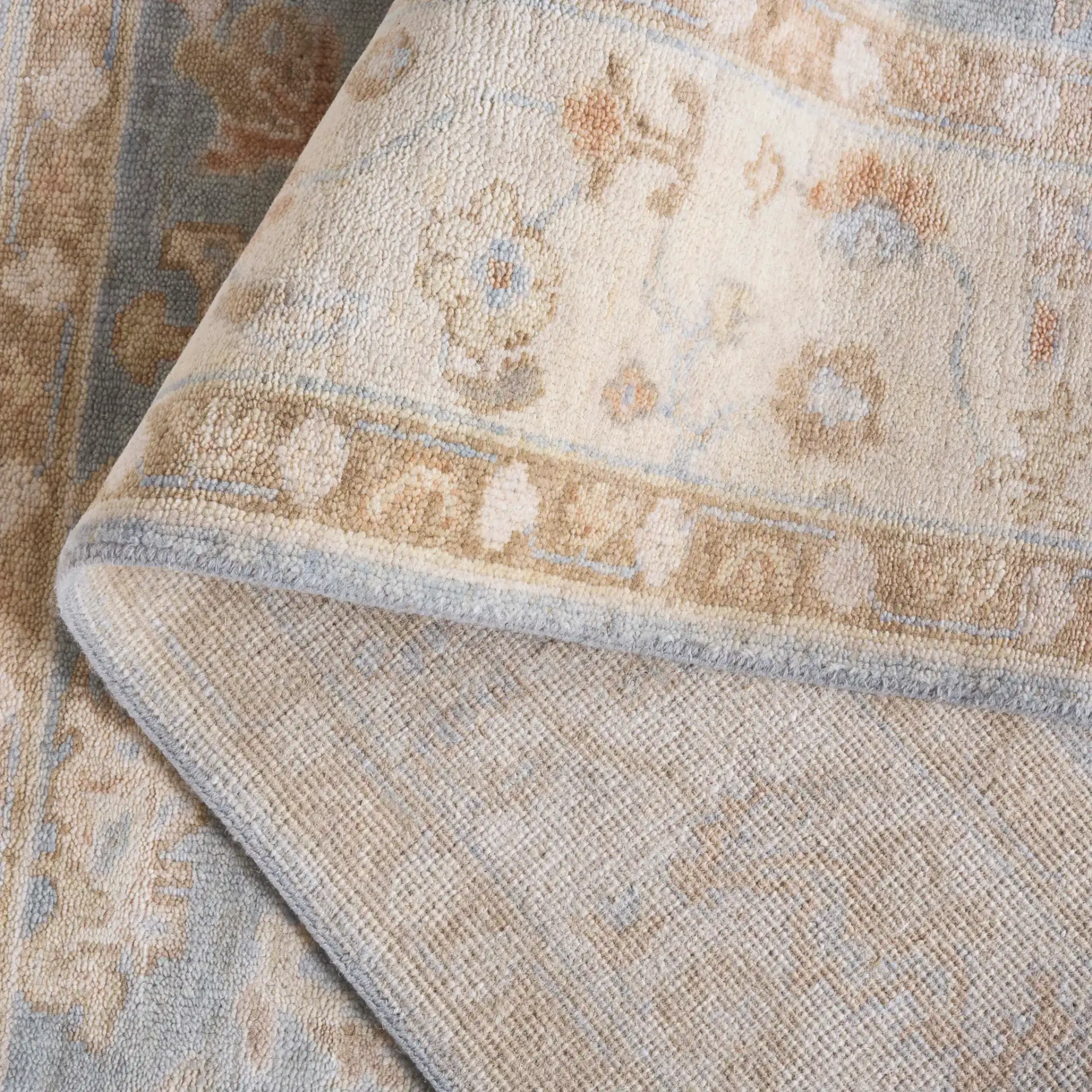 Oushak Allover Palmette Hand-Knotted Wool Rug in Light Blue / Beige in a styled room