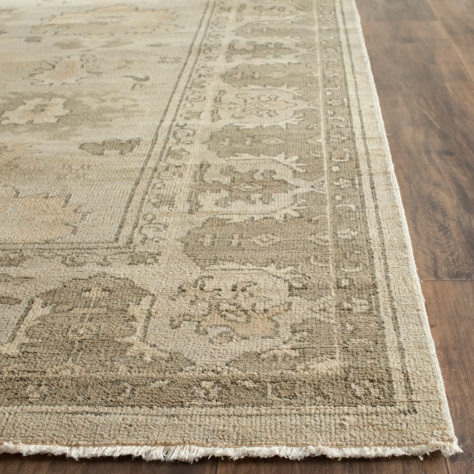 Oushak Scattered Floral Border Hand-Knotted Wool Rug in Silver / Gray in a styled room