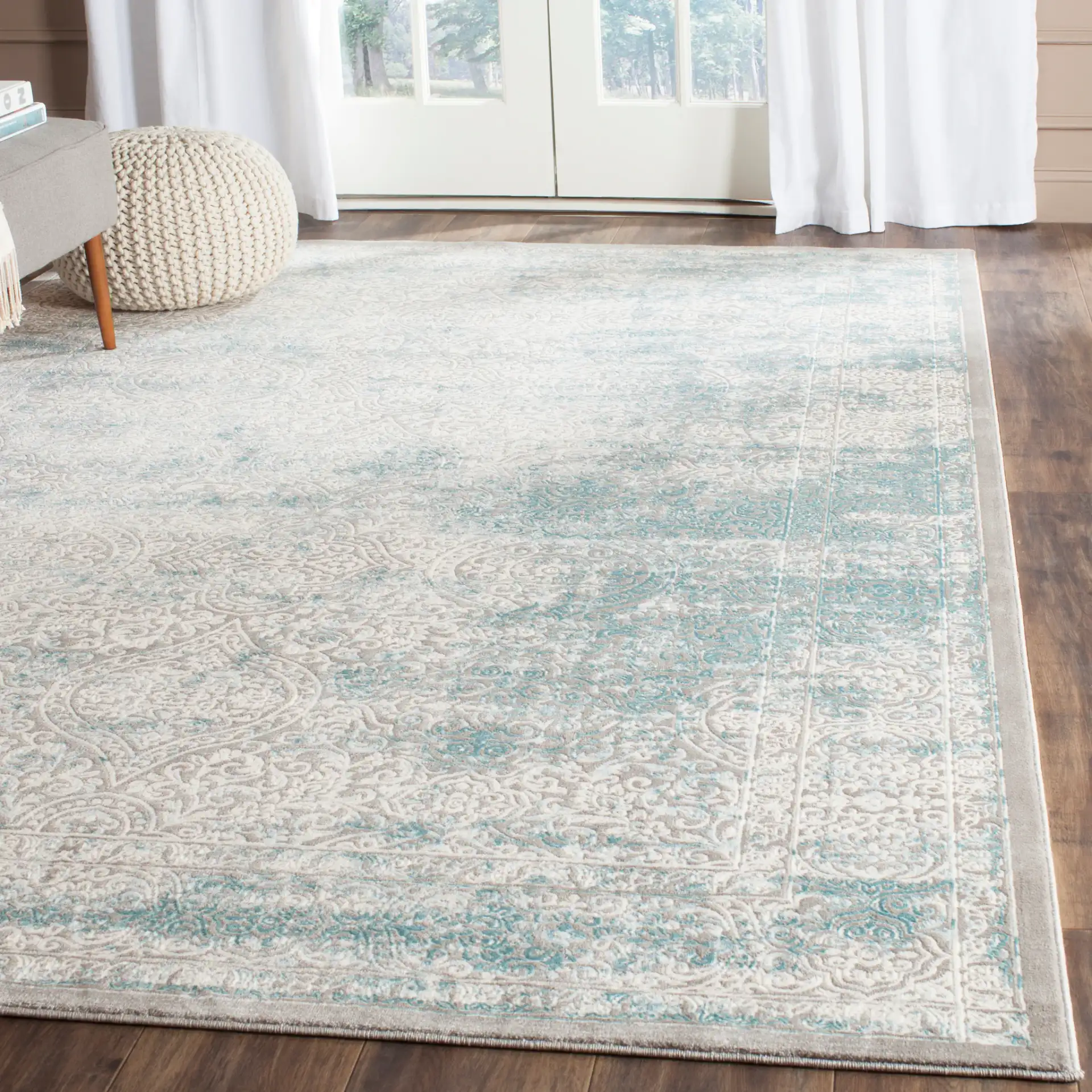Passion Distressed Floral Bordered Rug in Turquoise / Ivory in a styled room