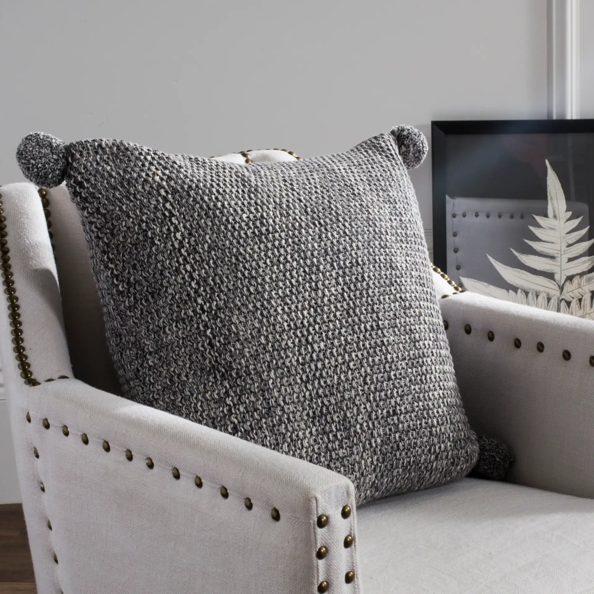 Pom Pom Knit Pillow in Dark Gray / Natural in a styled room