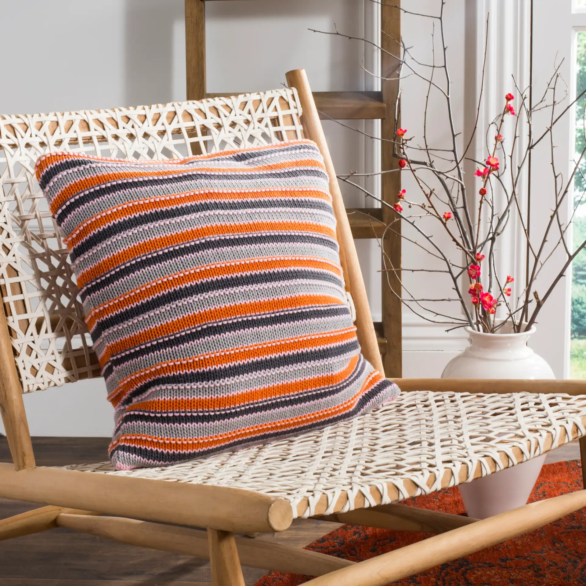 Candy Stripe Knit Pillow in Light Gray / Dark Gray / Orange / Pink in a styled room