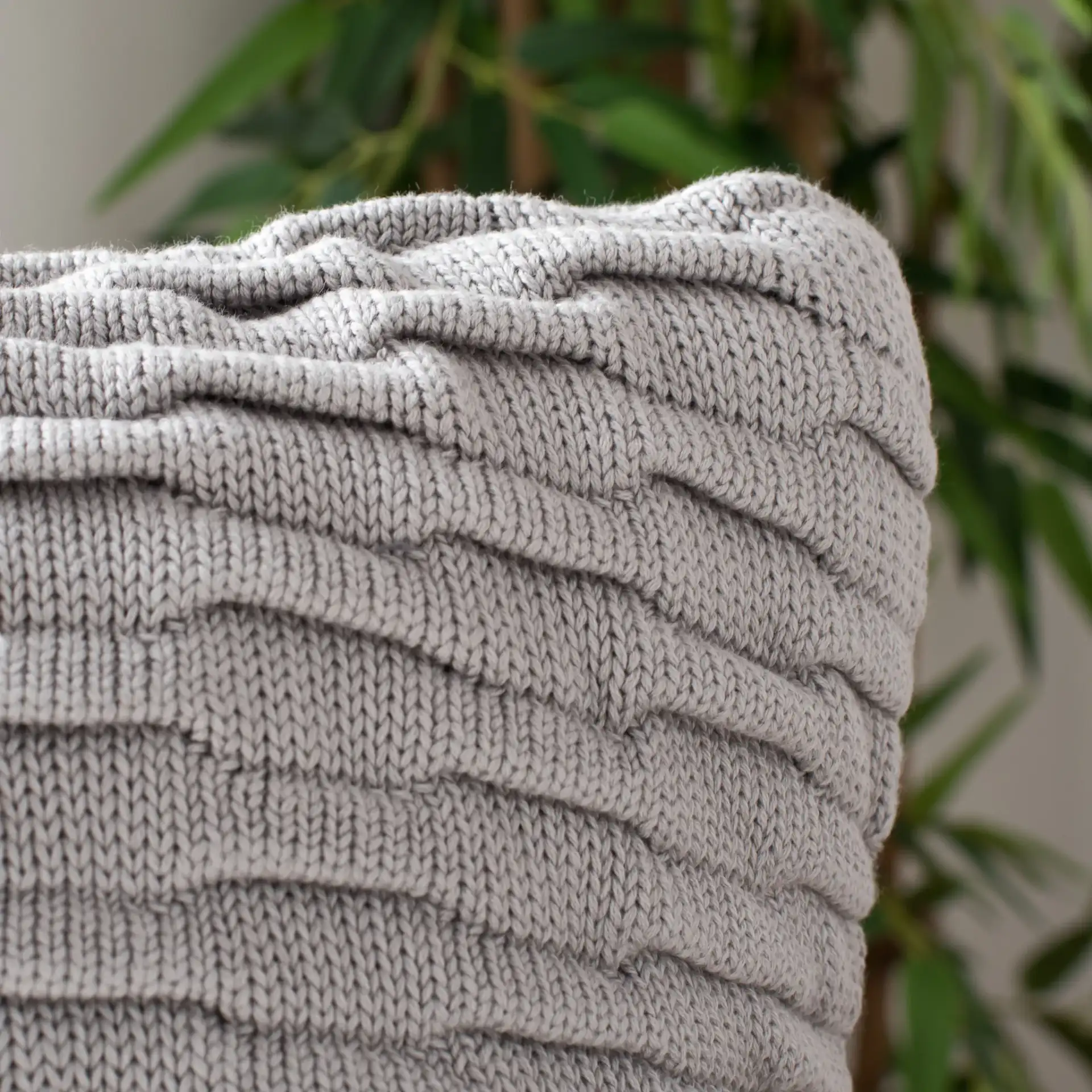 Noela Knit Pillow in Light Gray in a styled room