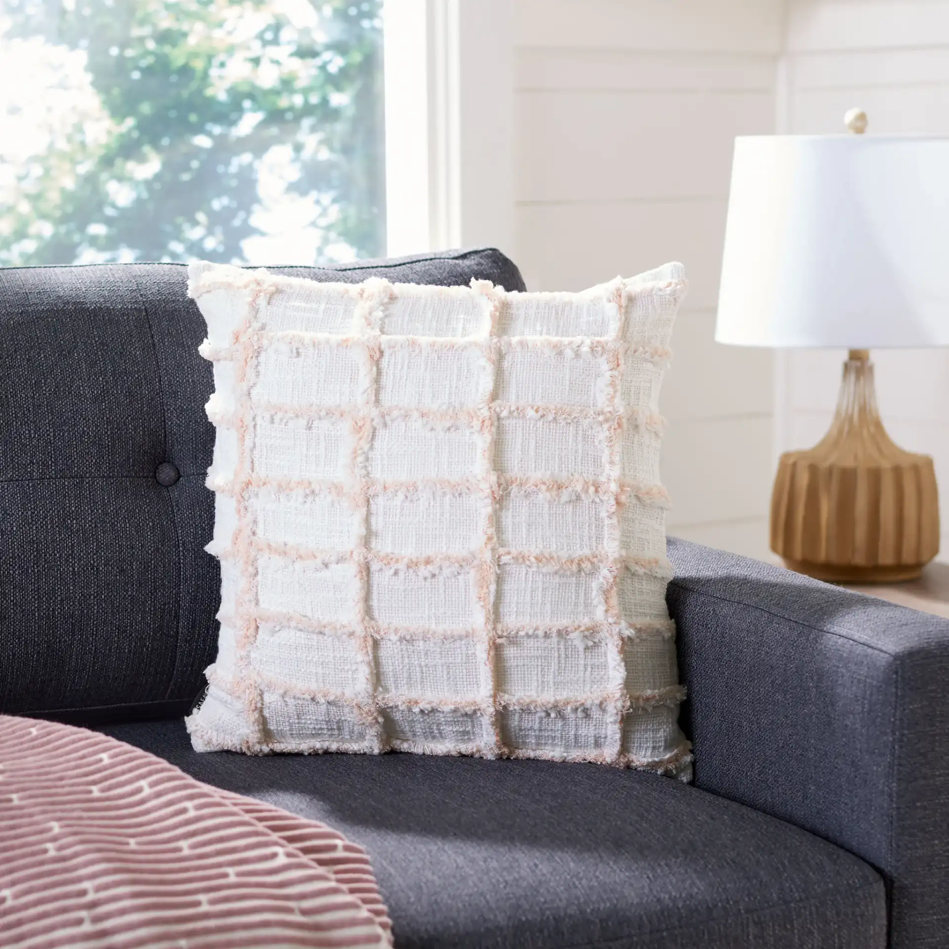 Lonis Pillow in White / Pink in a styled room