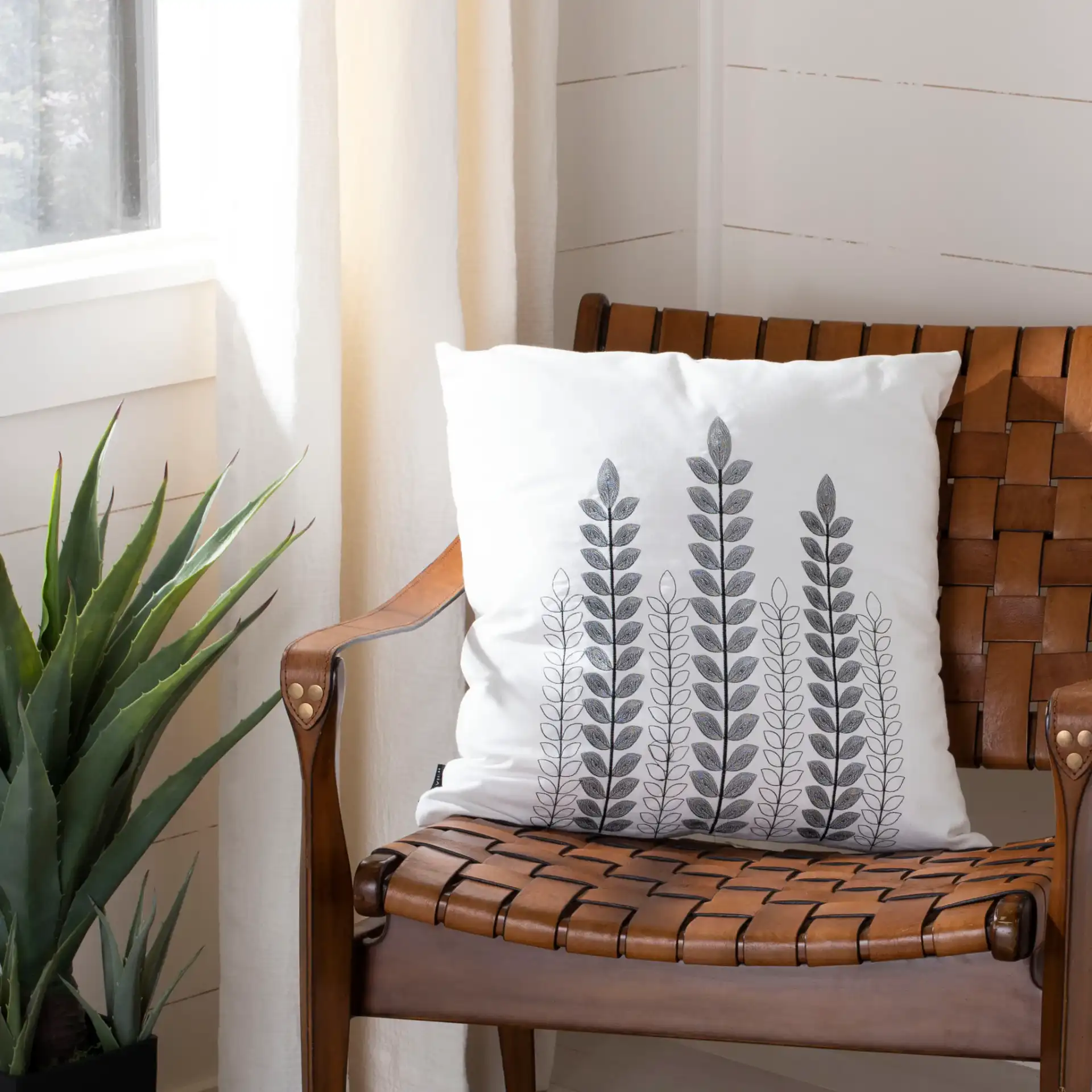 Valorie Vine Pillow in White / Gray in a styled room