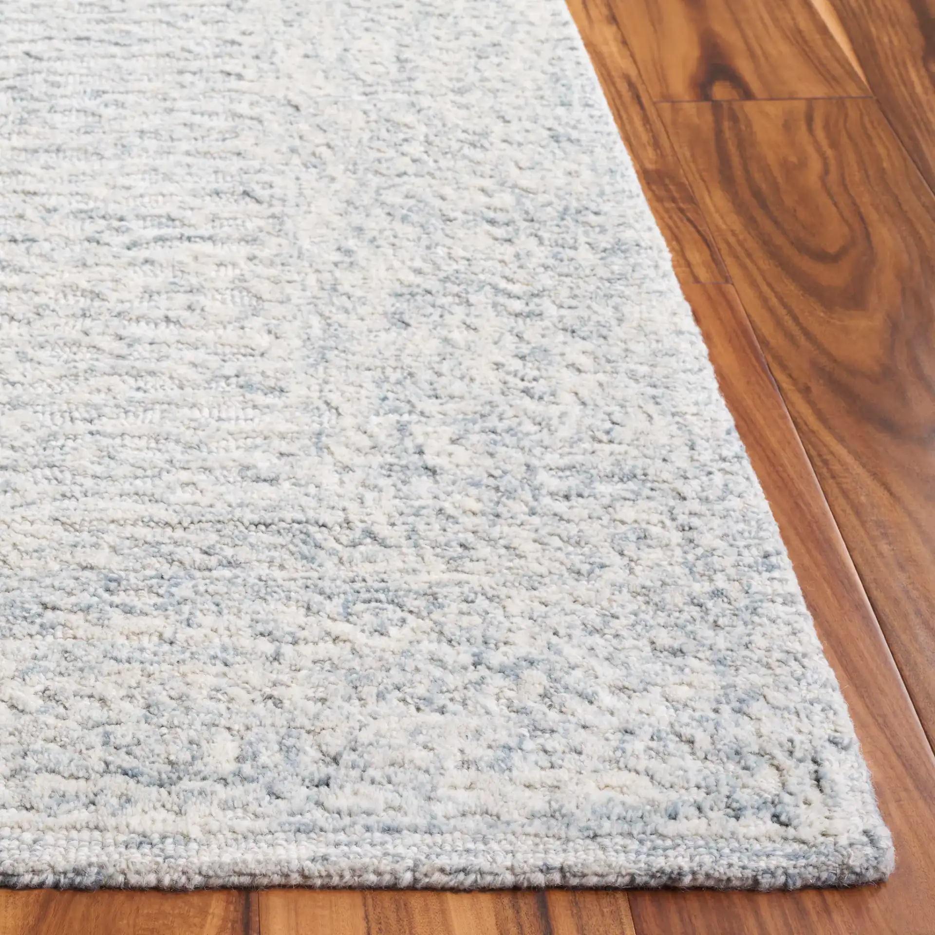 Pine Bordered Hand-Tufted Wool Rug in Light Blue / Ivory in a styled room