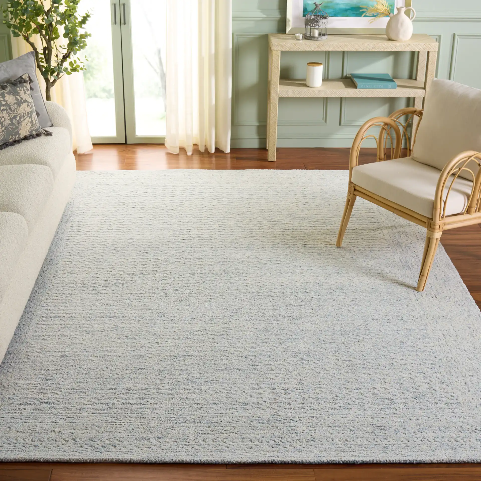 Pine Bordered Hand-Tufted Wool Rug in Light Blue / Ivory in a styled room