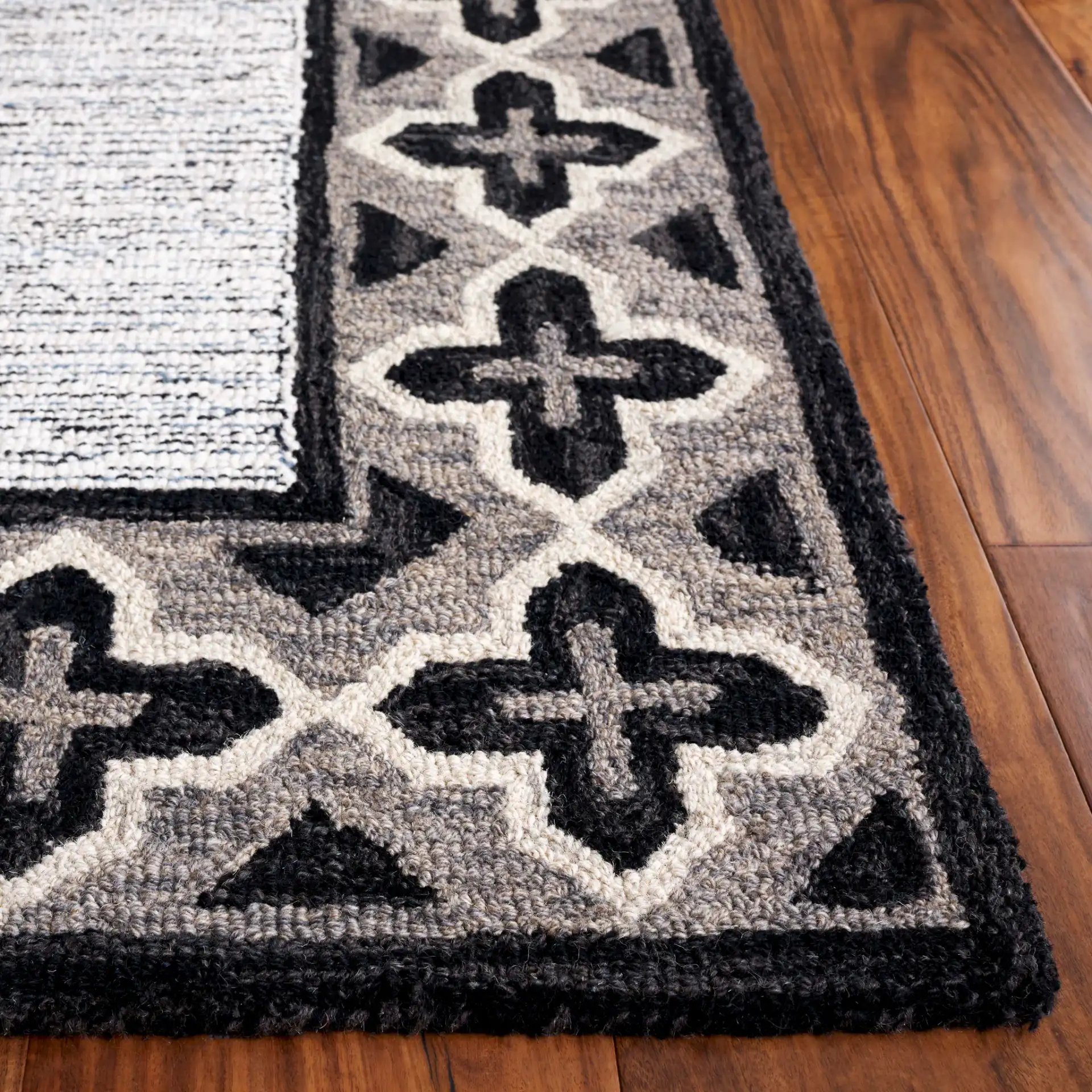 Pine Bordered Geometric Hand-Tufted Wool Rug in Charcoal / Ivory in a styled room