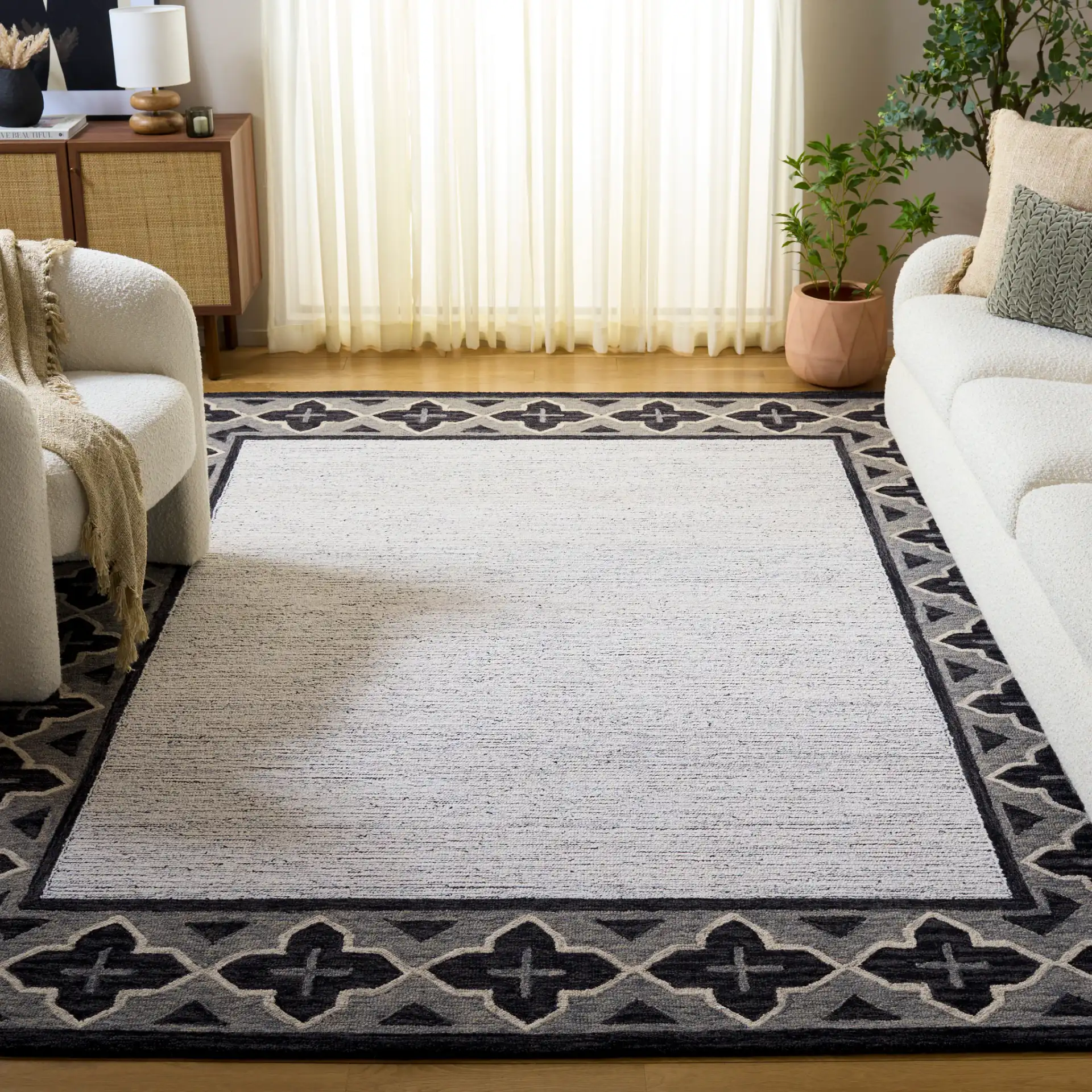 Pine Bordered Geometric Hand-Tufted Wool Rug in Charcoal / Ivory in a styled room