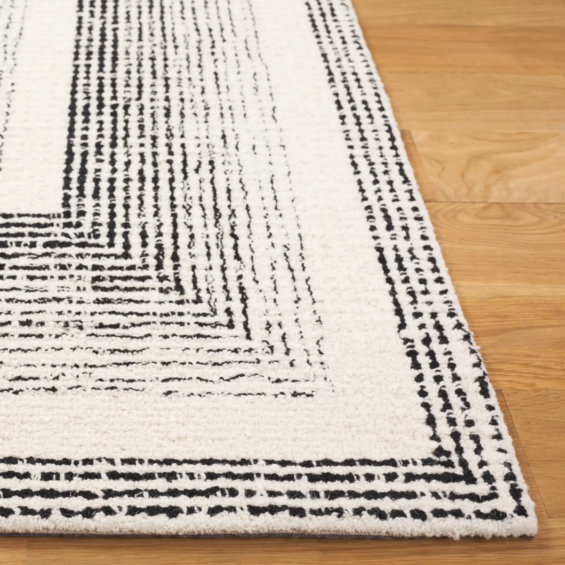 Pine Concentric Frame Hand-Tufted Wool Rug in Black / Ivory in a styled room