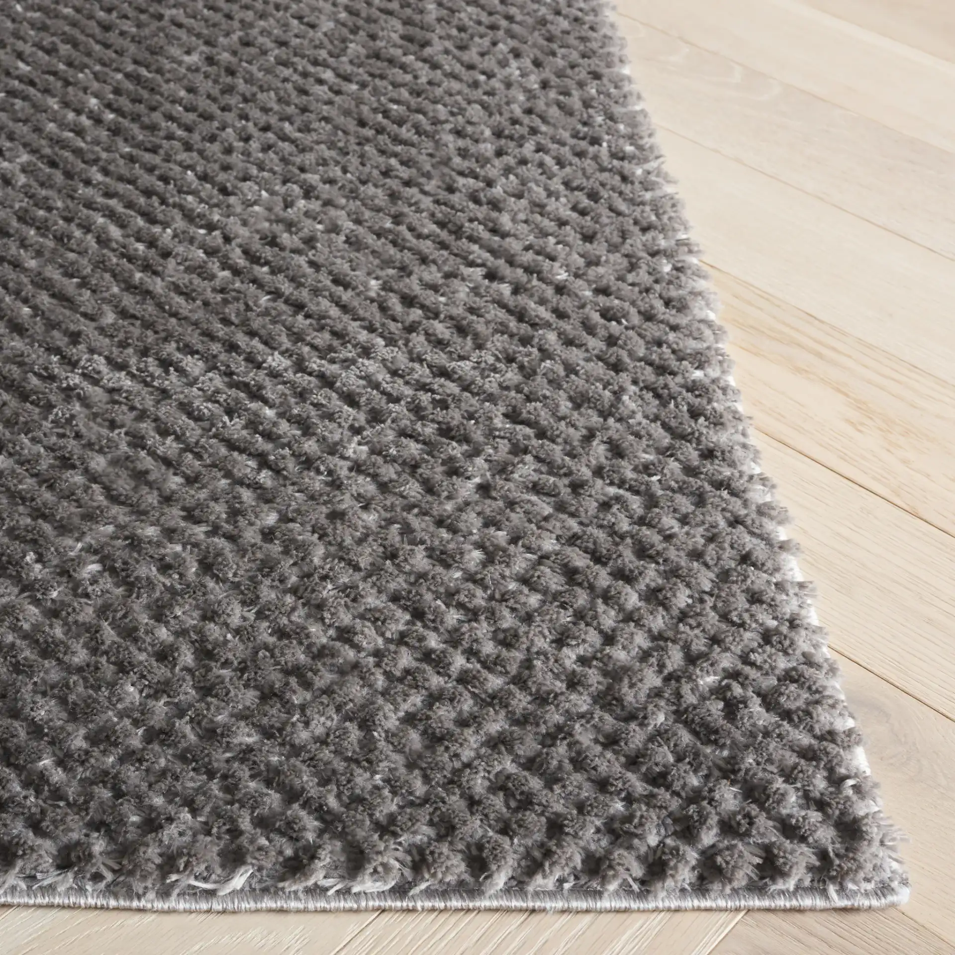 Penelope Textured Solid Shag Rug in Gray in a styled room
