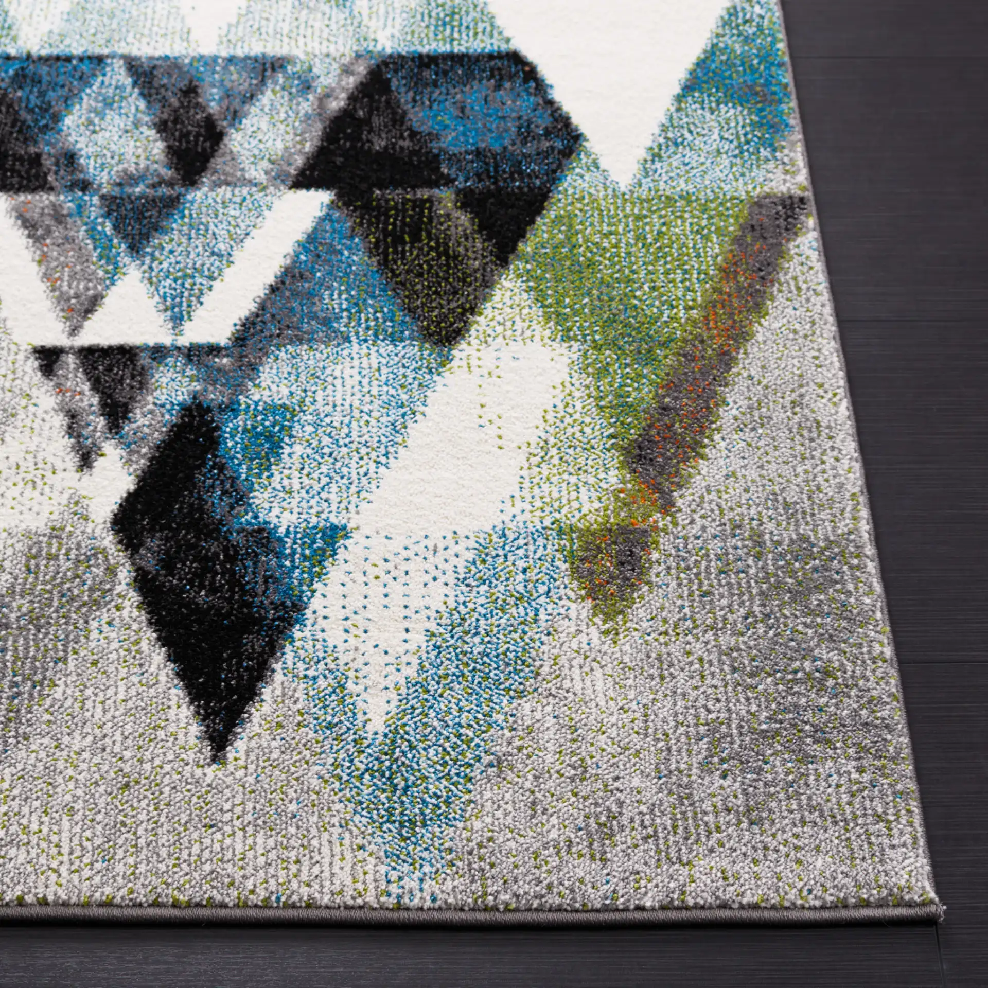 Porcello Overlapping Triangles Rug in Gray / Blue in a styled room