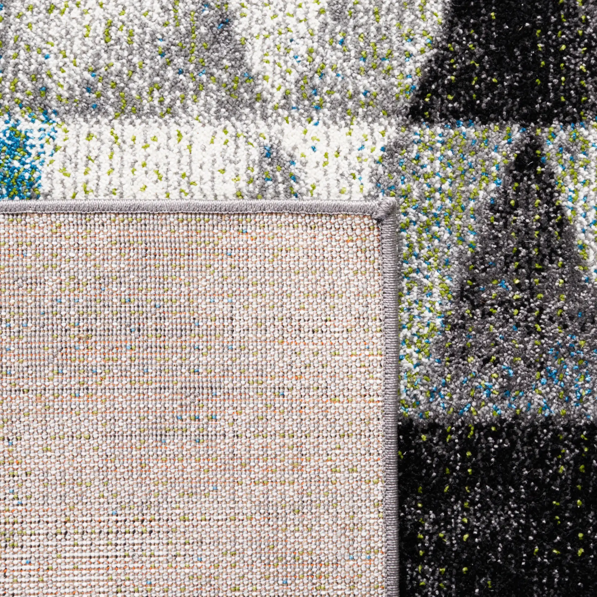 Porcello Overlapping Triangles Rug in Gray / Blue in a styled room