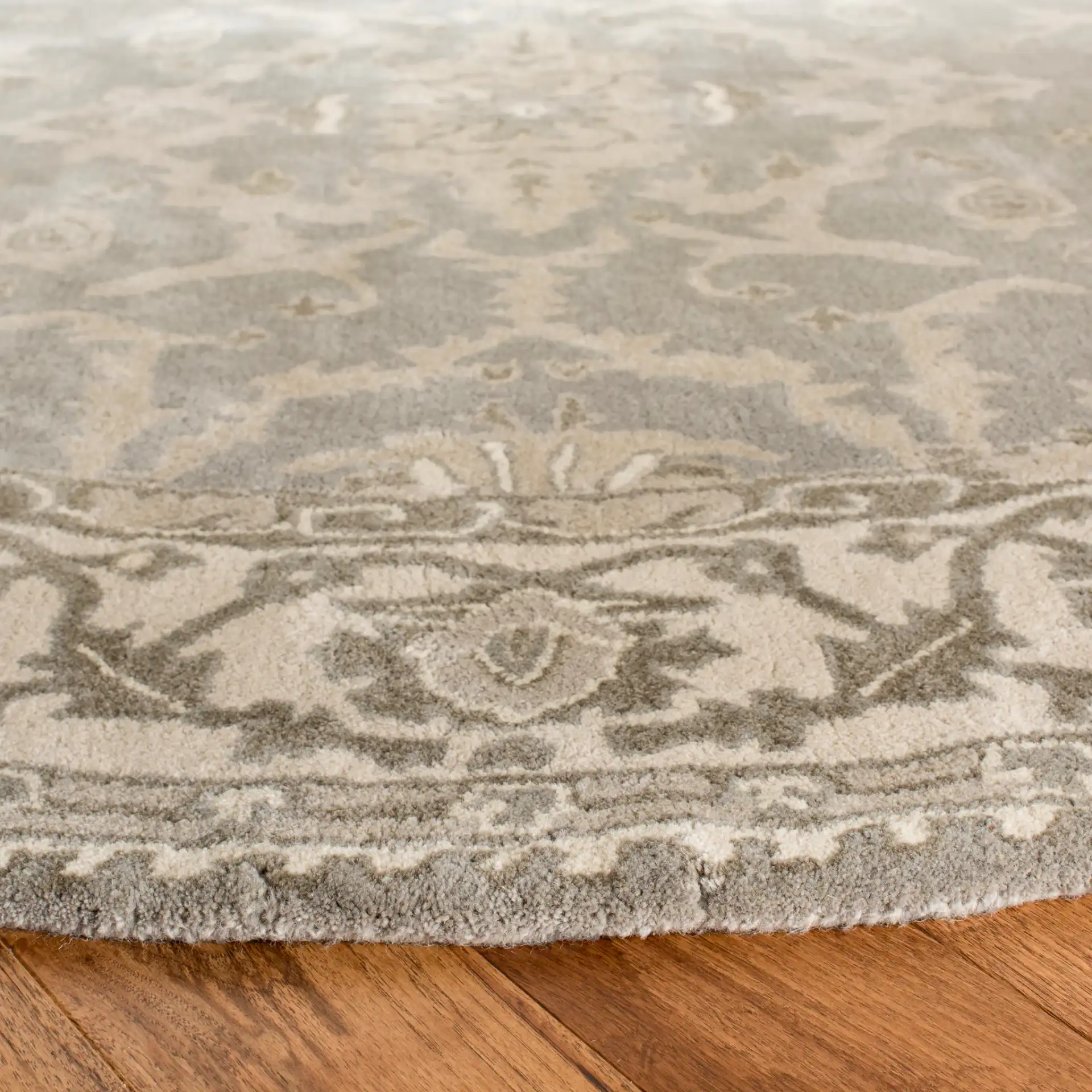 Royalty Palmette Bordered Hand-Tufted Wool Rug in Gray / Cream in a styled room