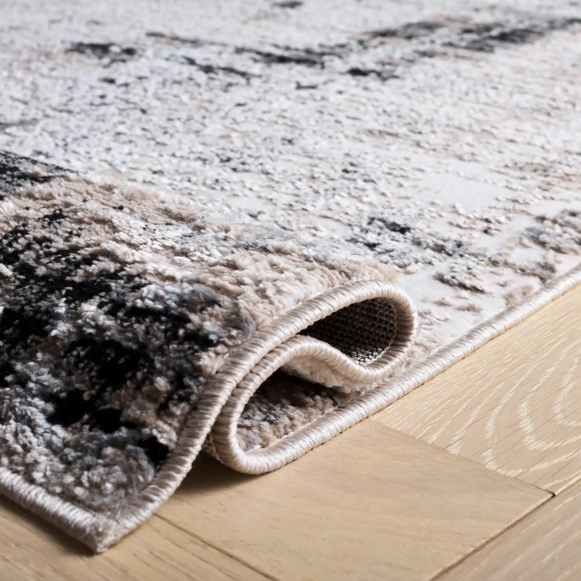 Sable Distressed Abstract Rug in Ivory / Gray Black in a styled room