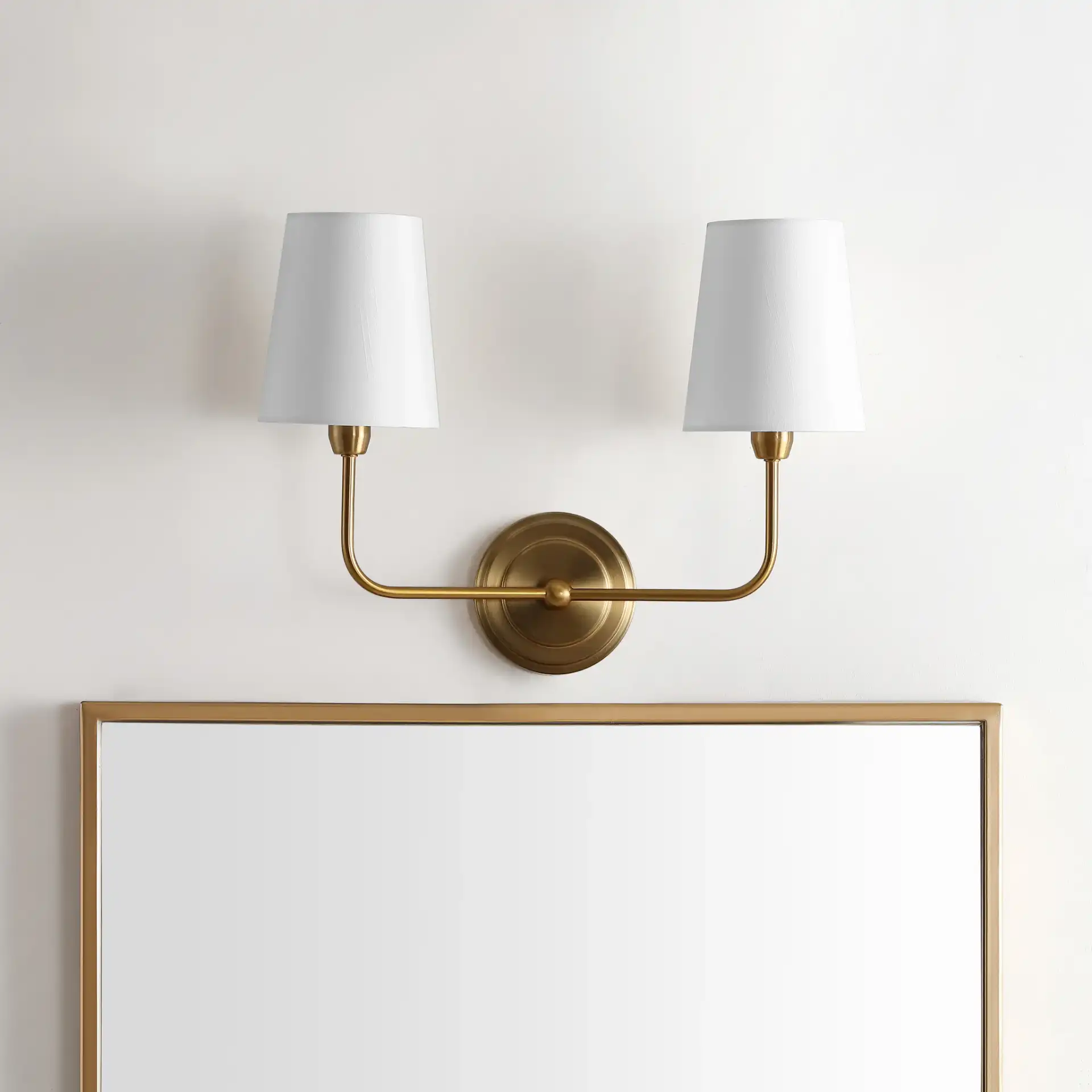 Ezra Two-Light Wall Sconce in Brass in a styled room