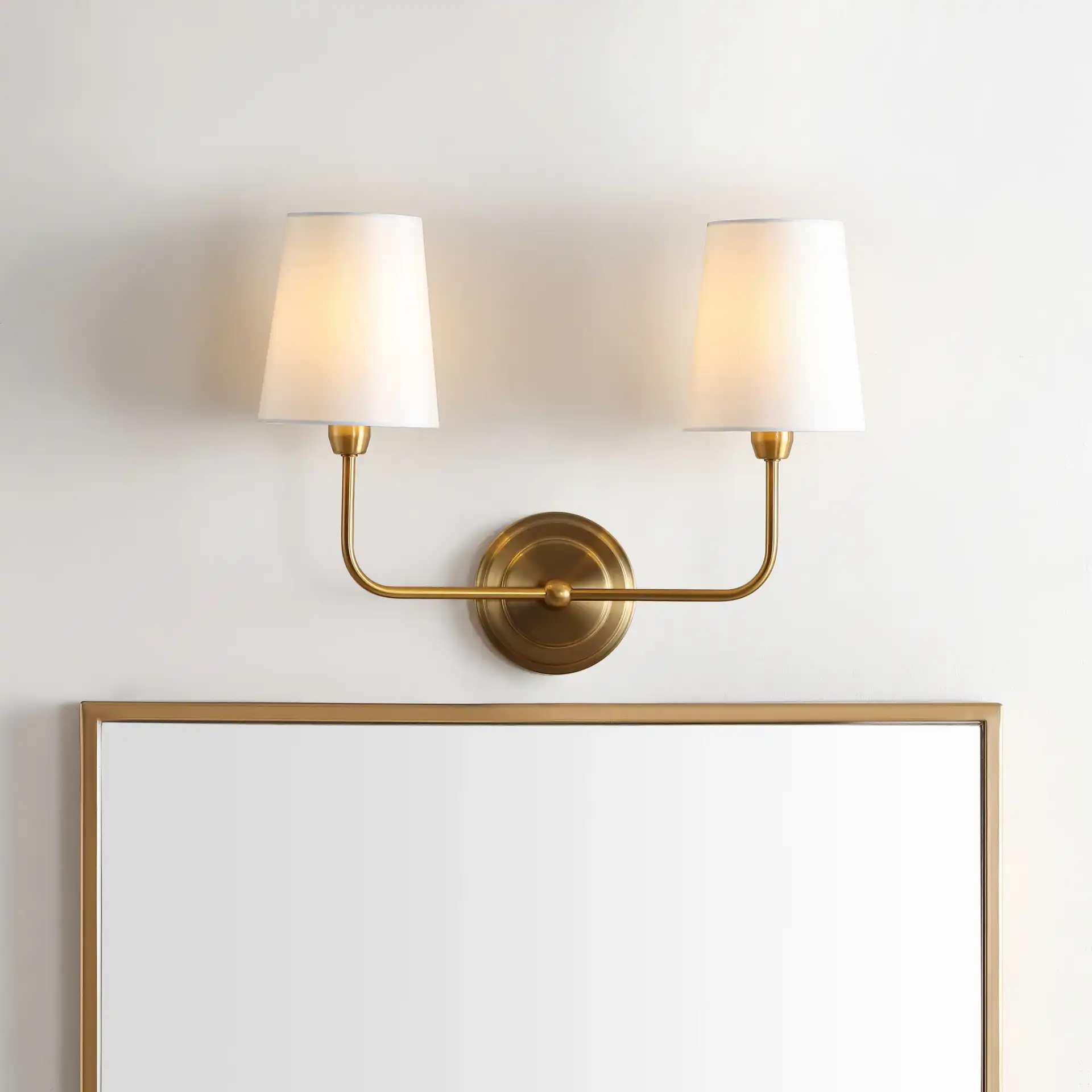 Ezra Two-Light Wall Sconce in Brass in a styled room