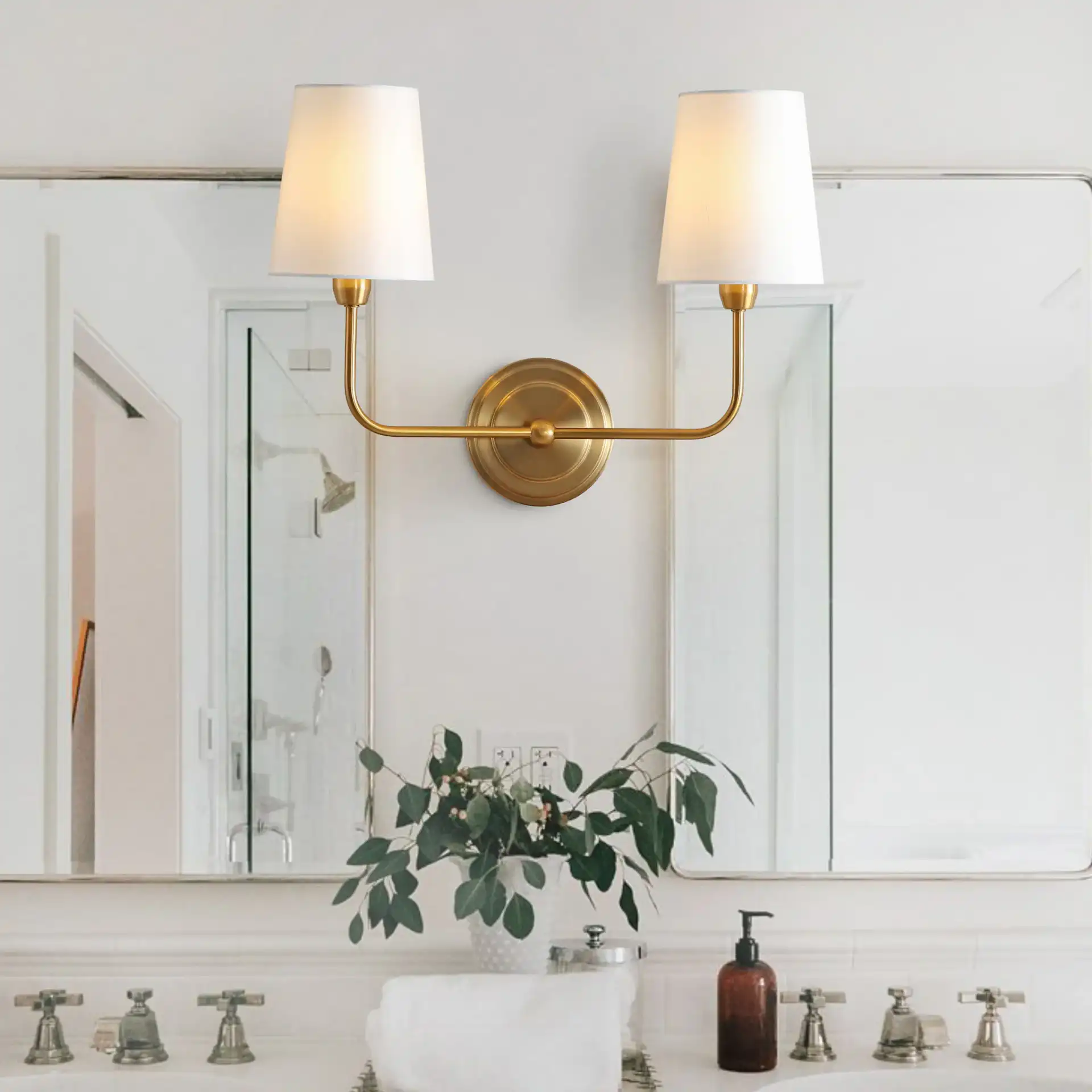 Ezra Two-Light Wall Sconce in Brass in a styled room