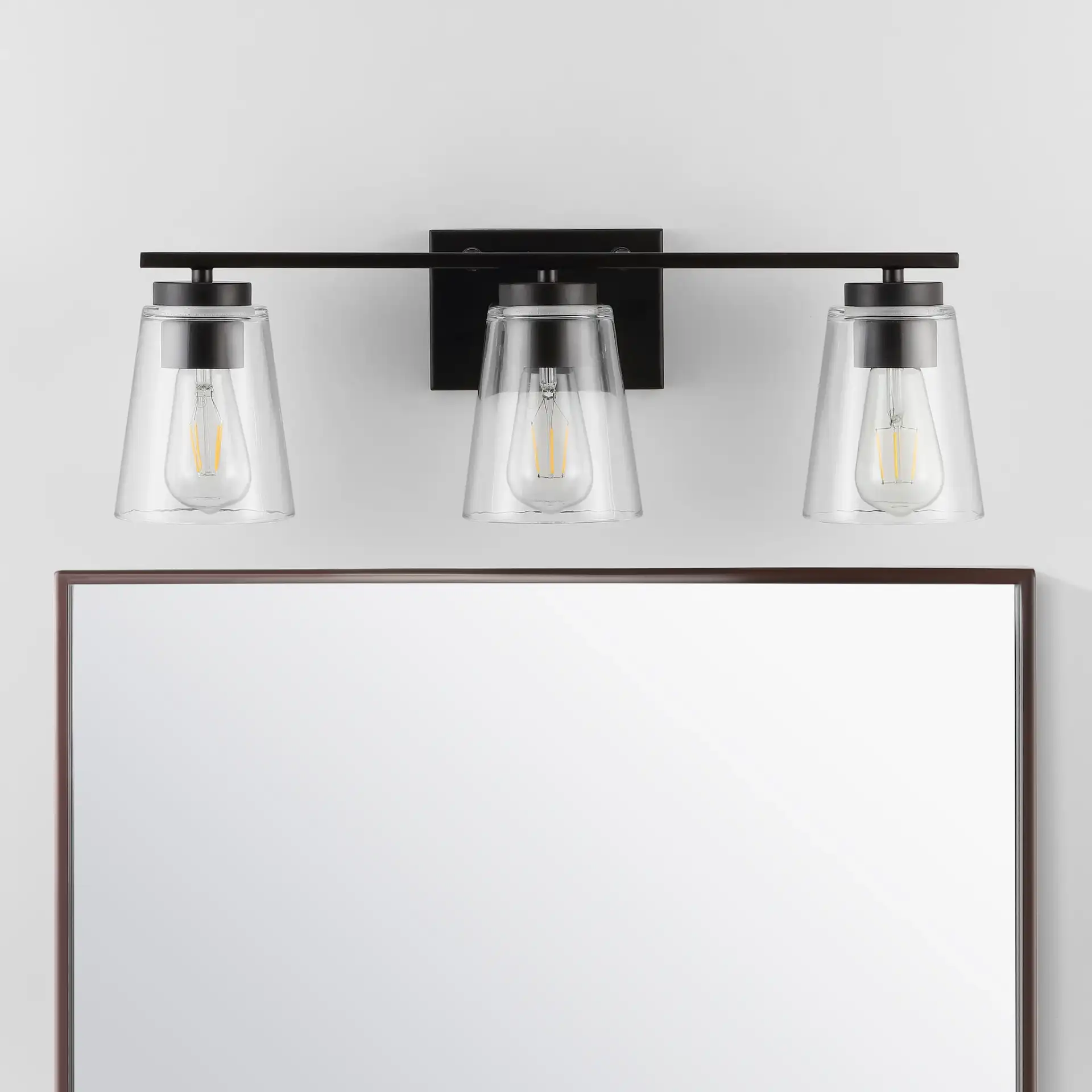 Grezler Three-Light Wall Sconce in Oil Rub Bronze / Clear in a styled room