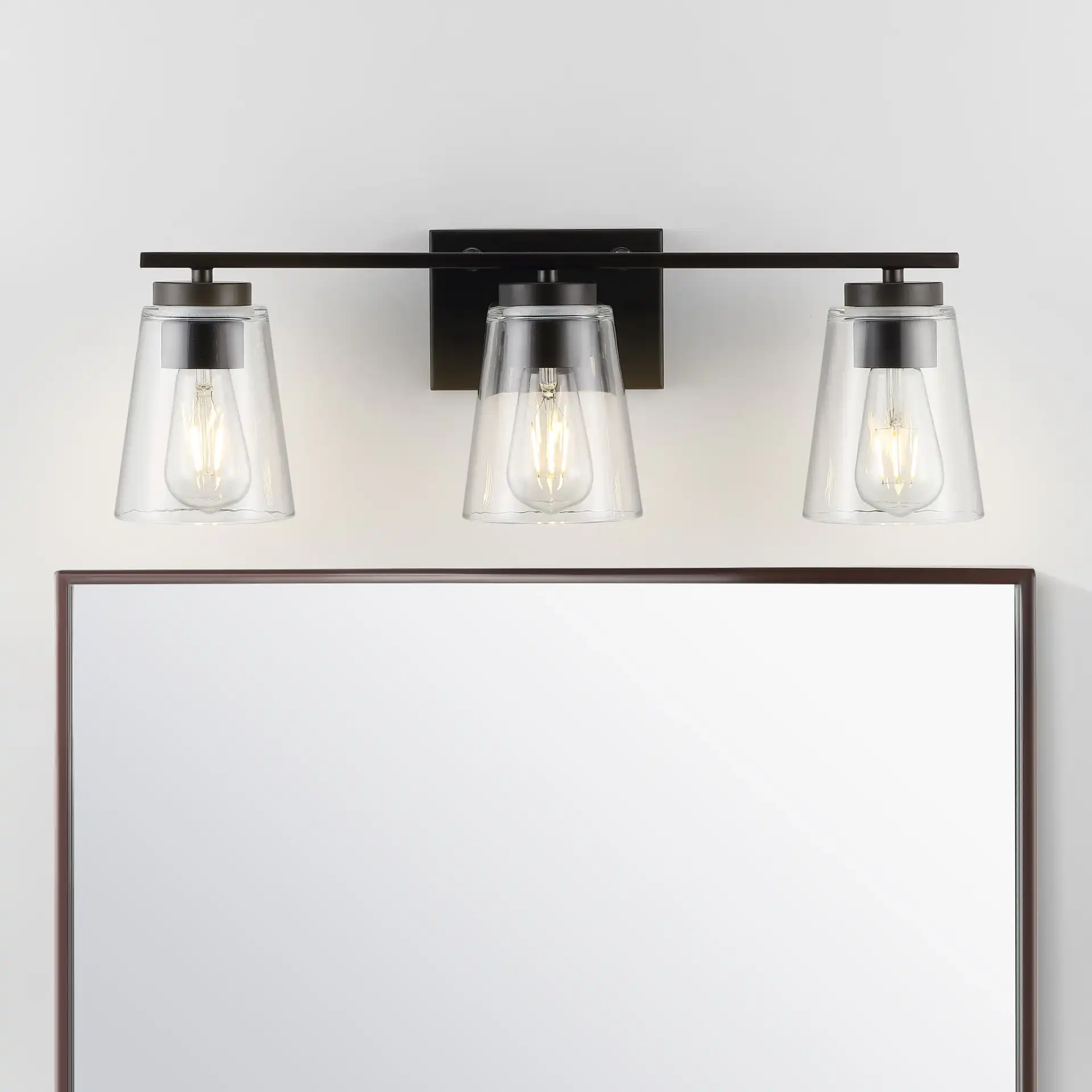 Grezler Three-Light Wall Sconce in Oil Rub Bronze / Clear in a styled room