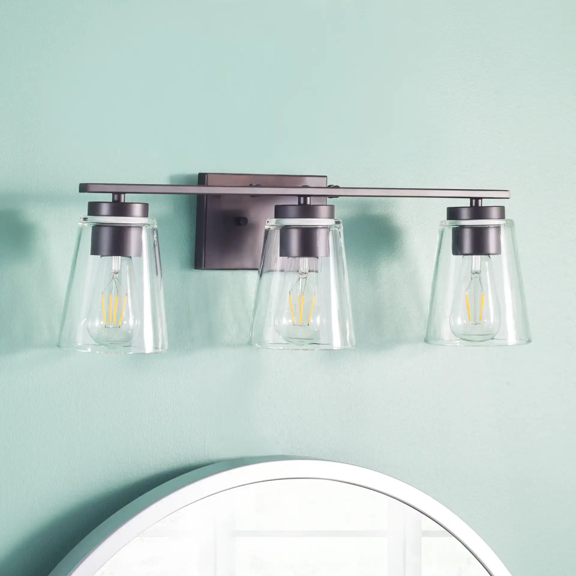 Grezler Three-Light Wall Sconce in Oil Rub Bronze / Clear in a styled room