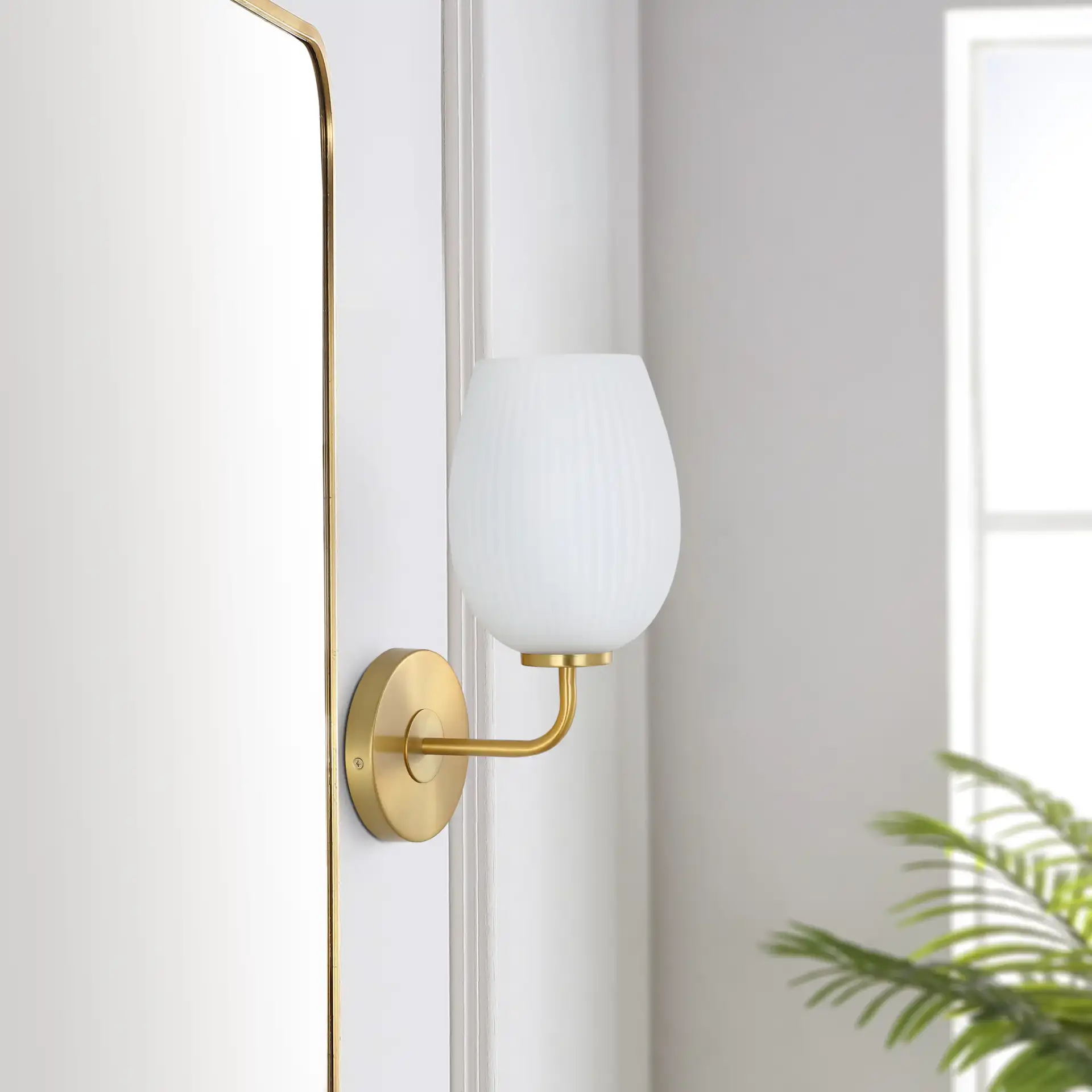 Idina Wall Sconce in Brass / White in a styled room