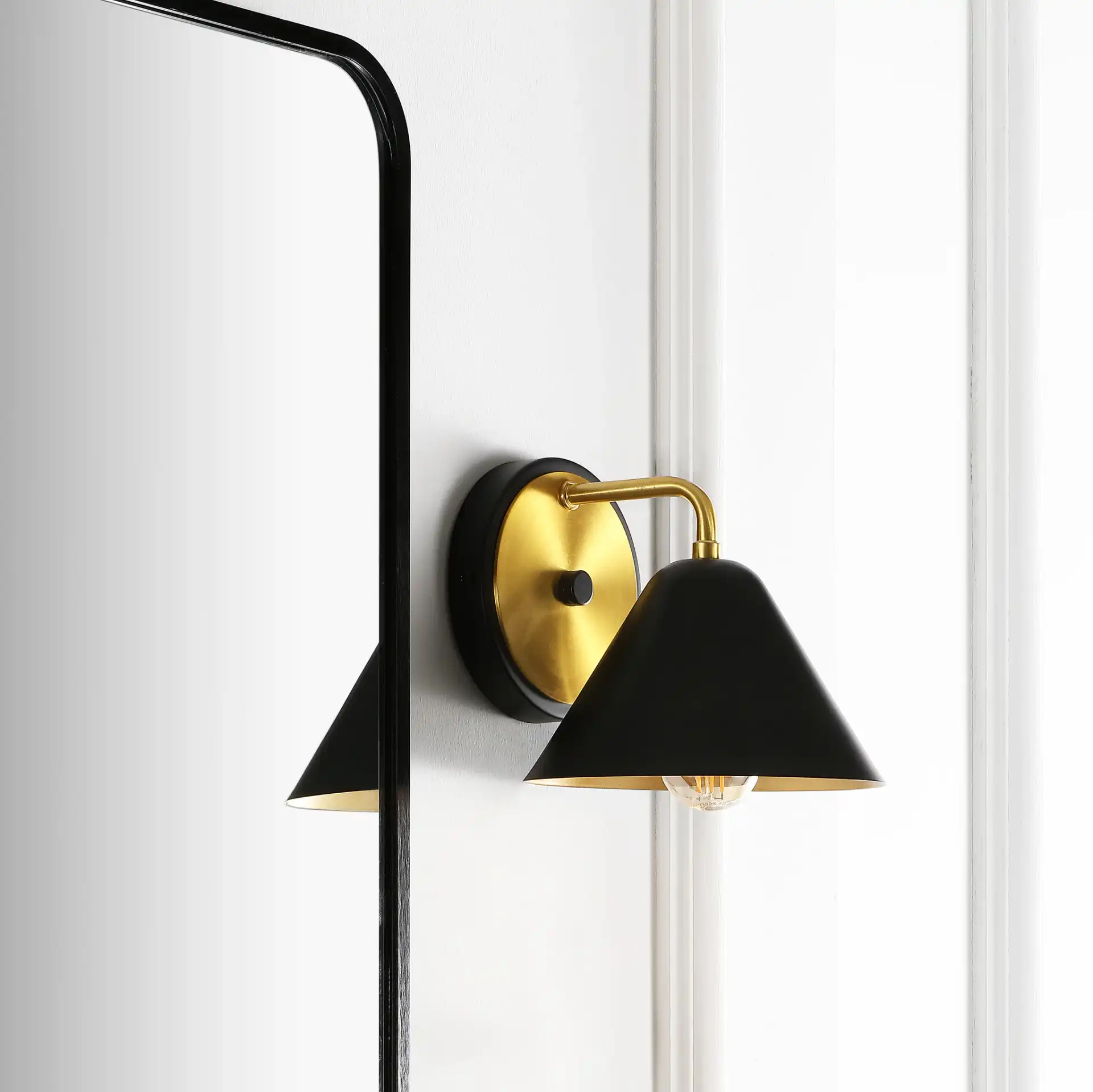 Jynn Wall Sconce in Black / Brass in a styled room