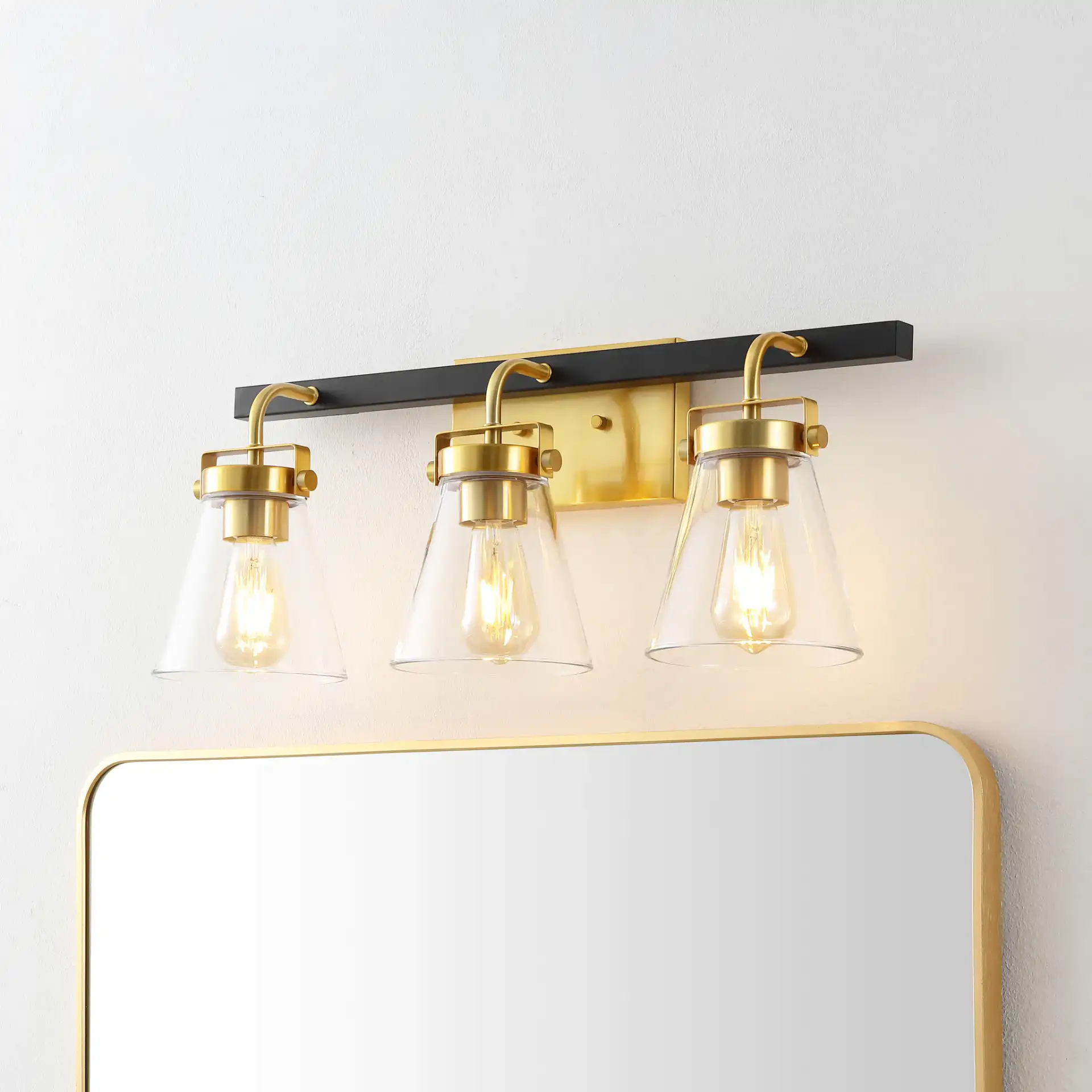 Rayney Three-Light Wall Sconce in Brass / Black in a styled room