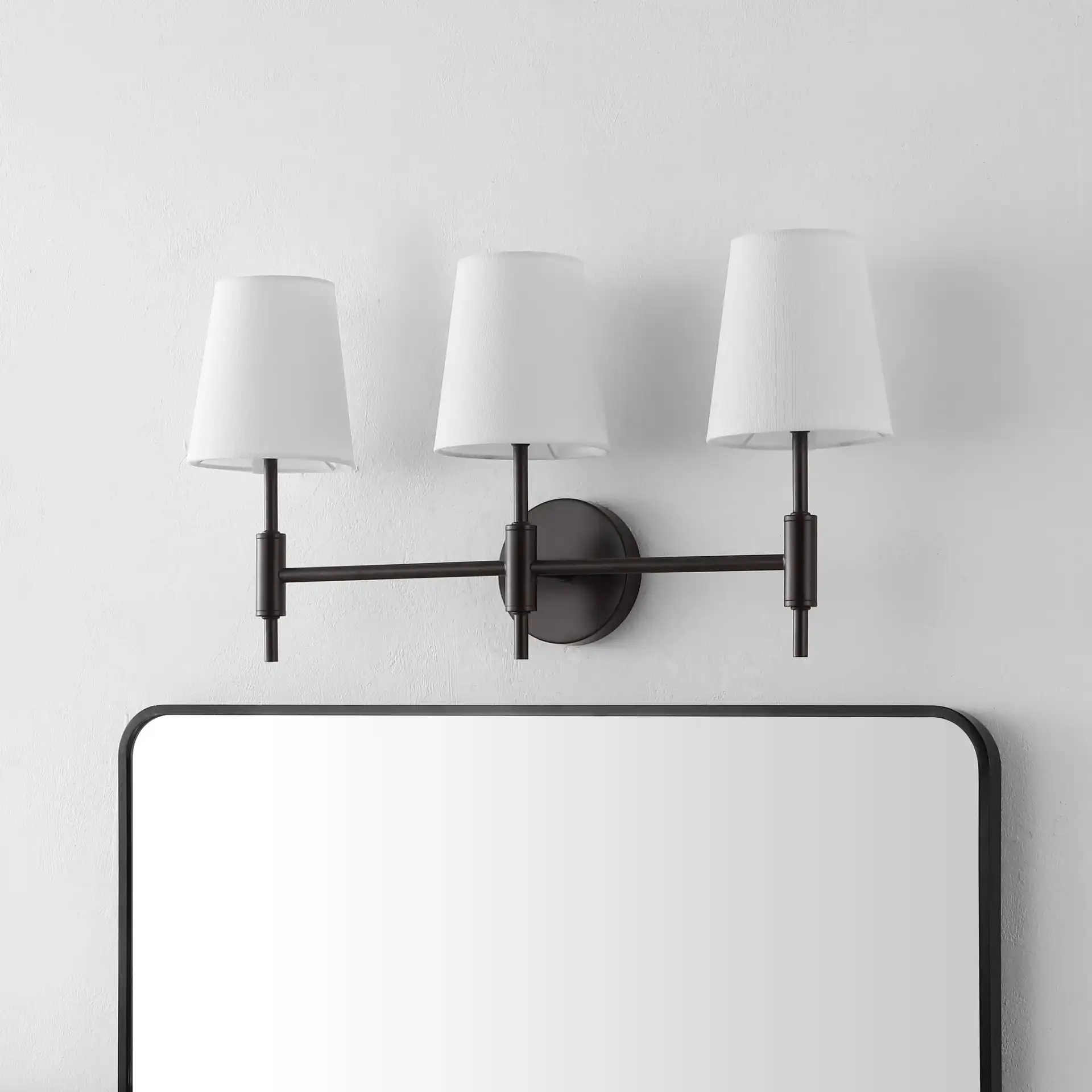 Darya Three-Light Wall Sconce in Black in a styled room
