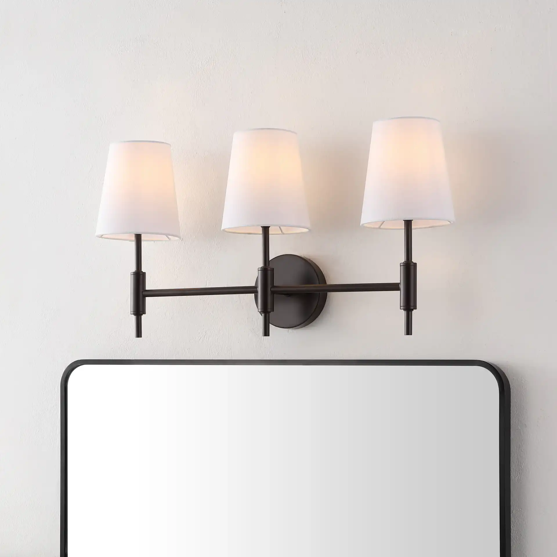 Darya Three-Light Wall Sconce in Black in a styled room