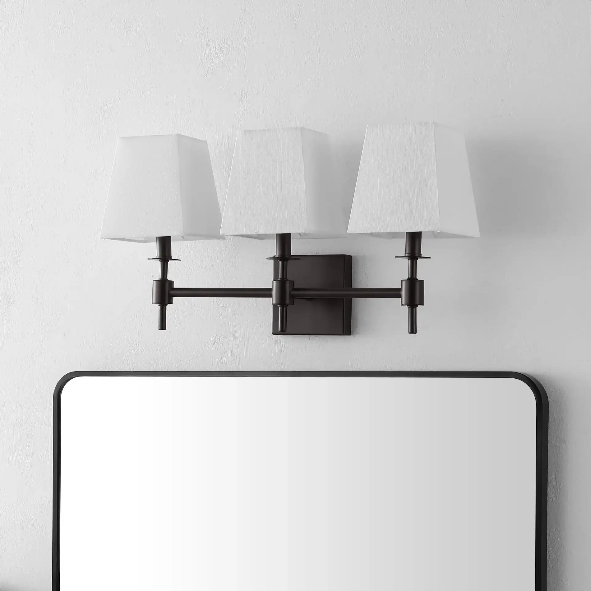 Clelia Three-Light Wall Sconce in Black in a styled room