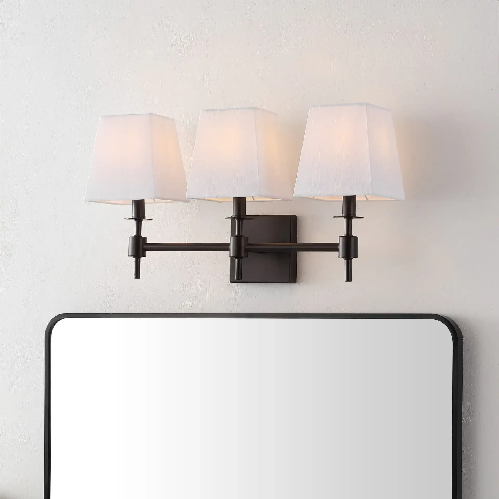 Clelia Three-Light Wall Sconce in Black in a styled room