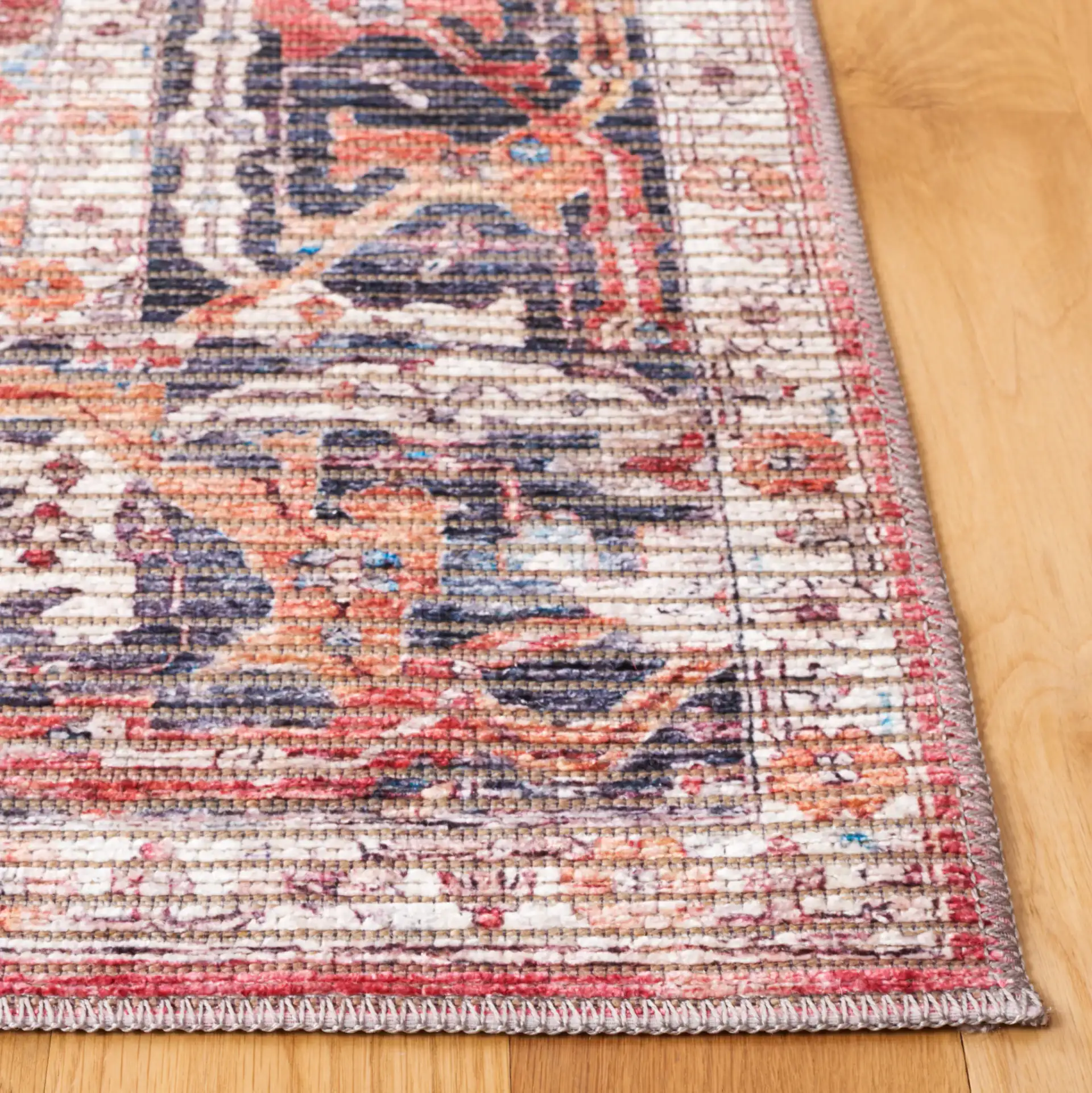 Serapi Distressed Floral Washable Rug in Rust / Gray in a styled room