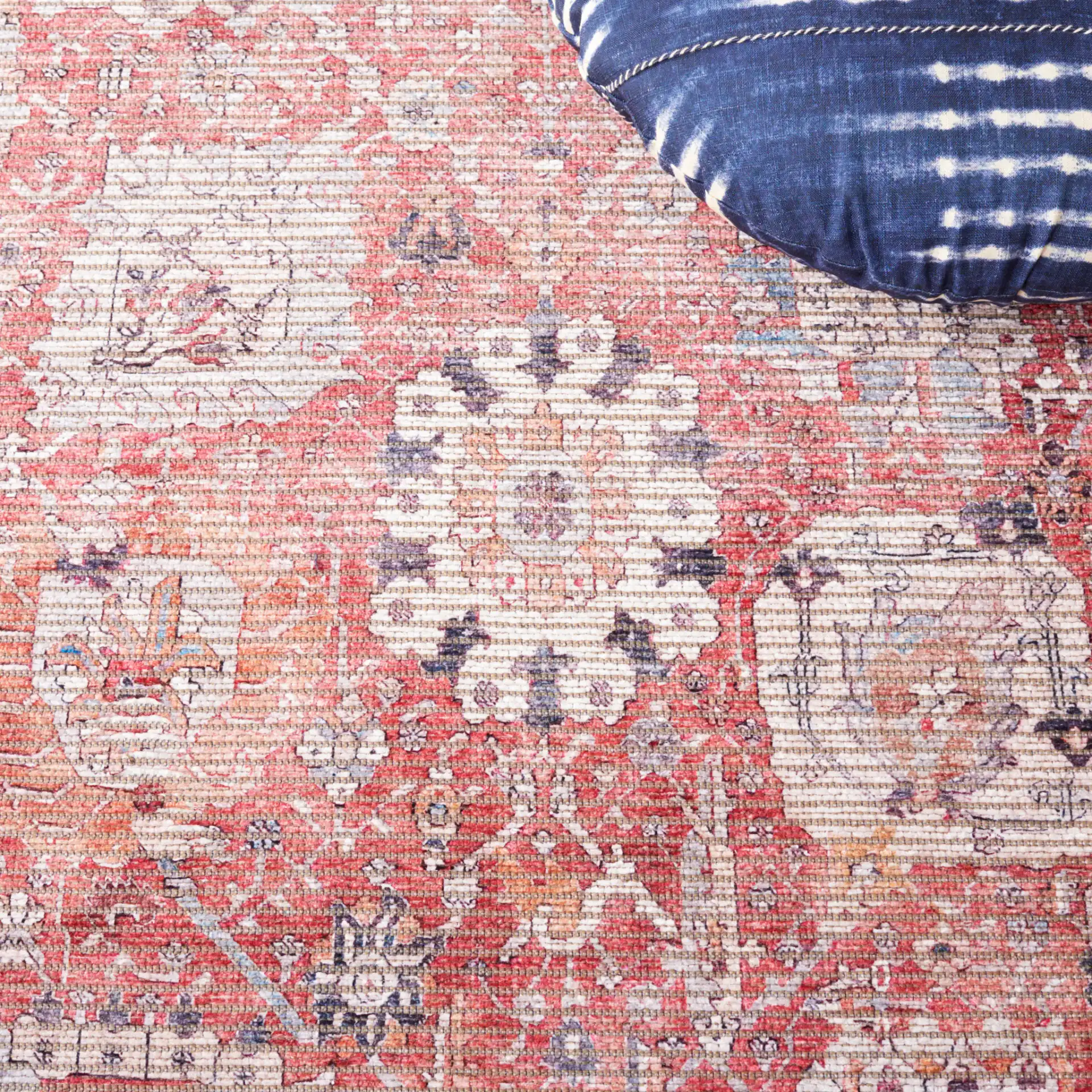Serapi Distressed Floral Washable Rug in Rust / Gray in a styled room