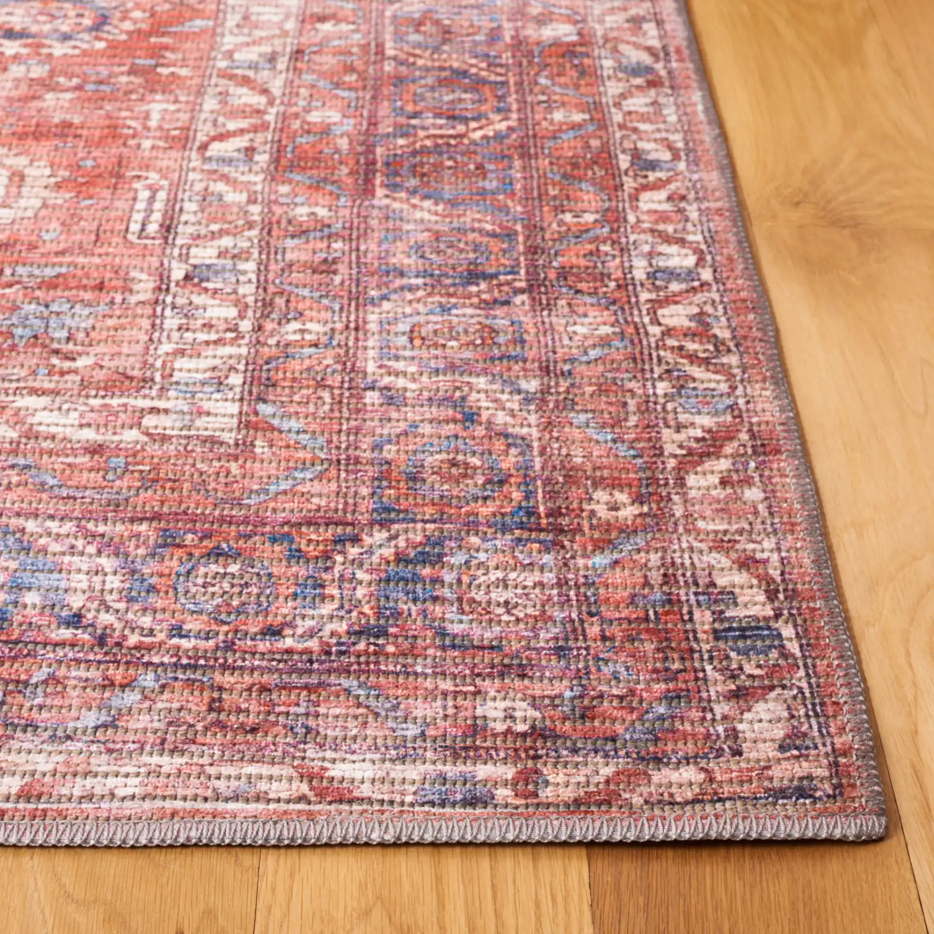 Serapi Distressed Geometric Washable Rug in Rust / Blue in a styled room