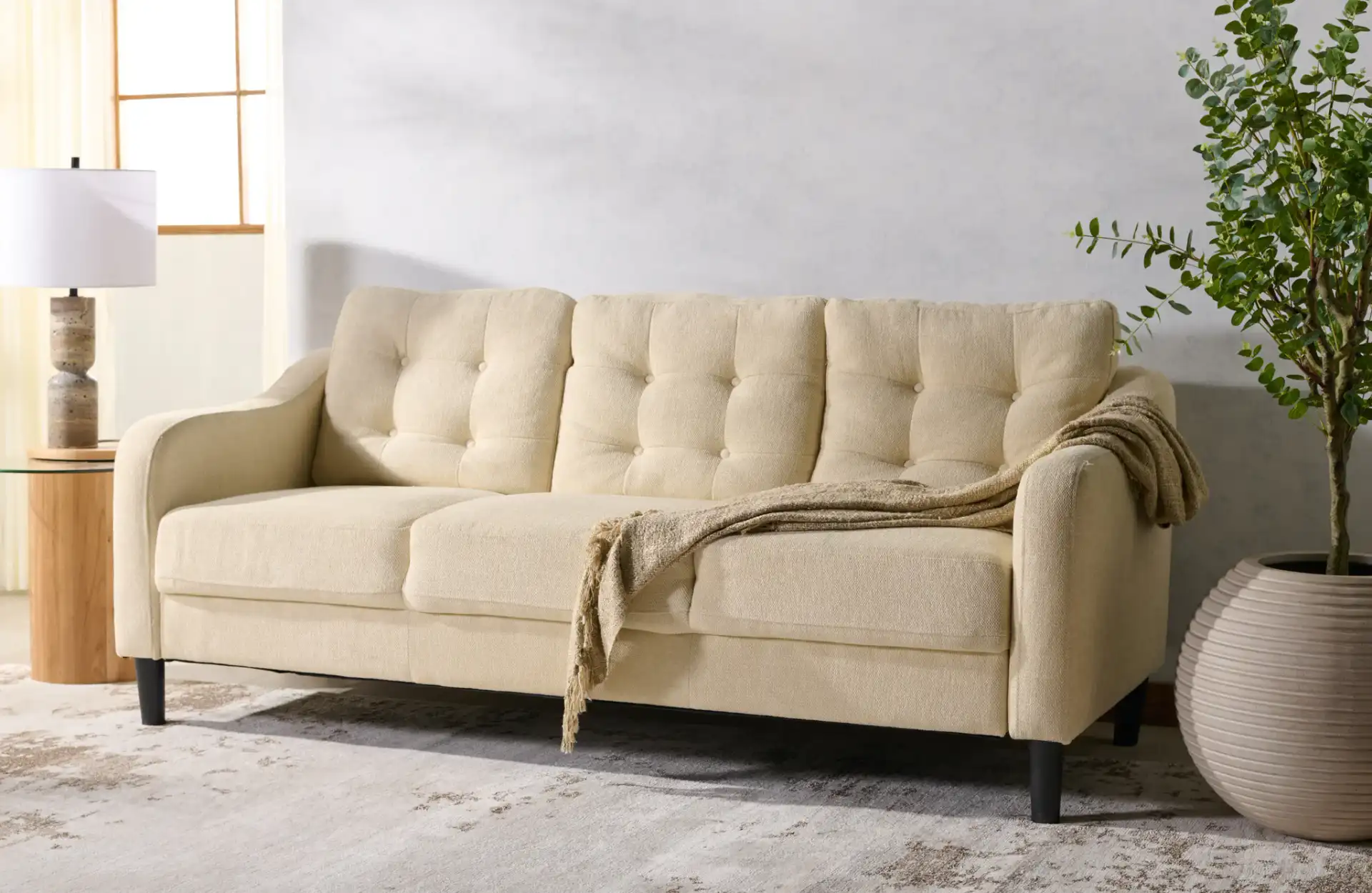 Nathaniel Tufted Three-Seater Sofa in Cream in a styled room
