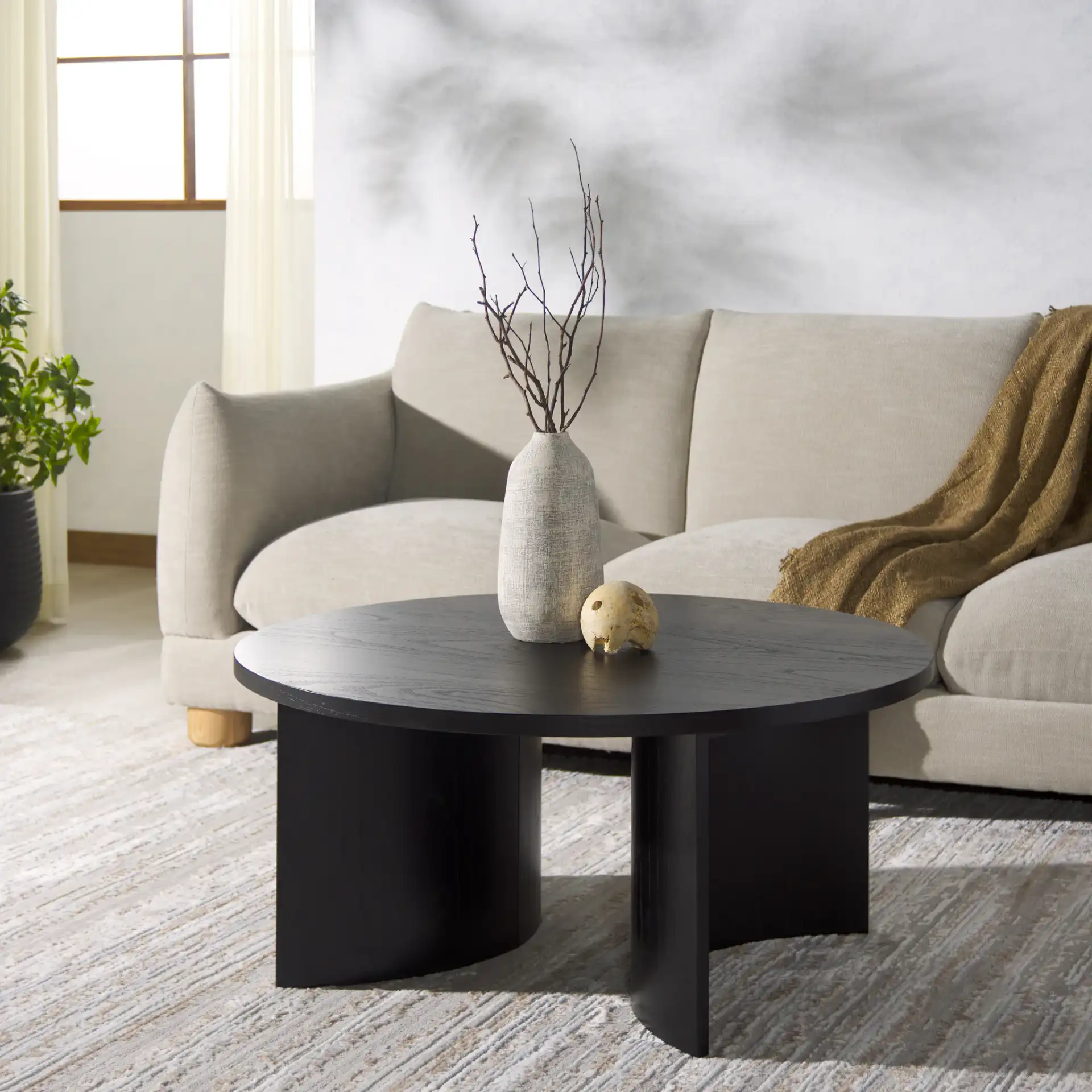 Audriella Round Wood Coffee Table in Black in a styled room