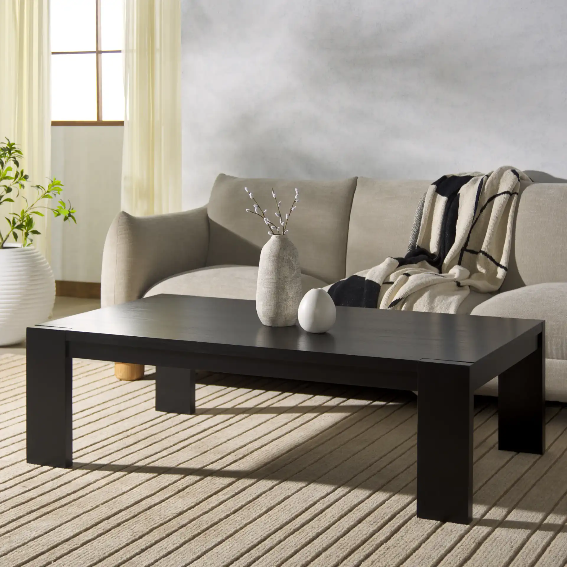 Nikole Rectangular Wood Coffee Table in Black in a styled room