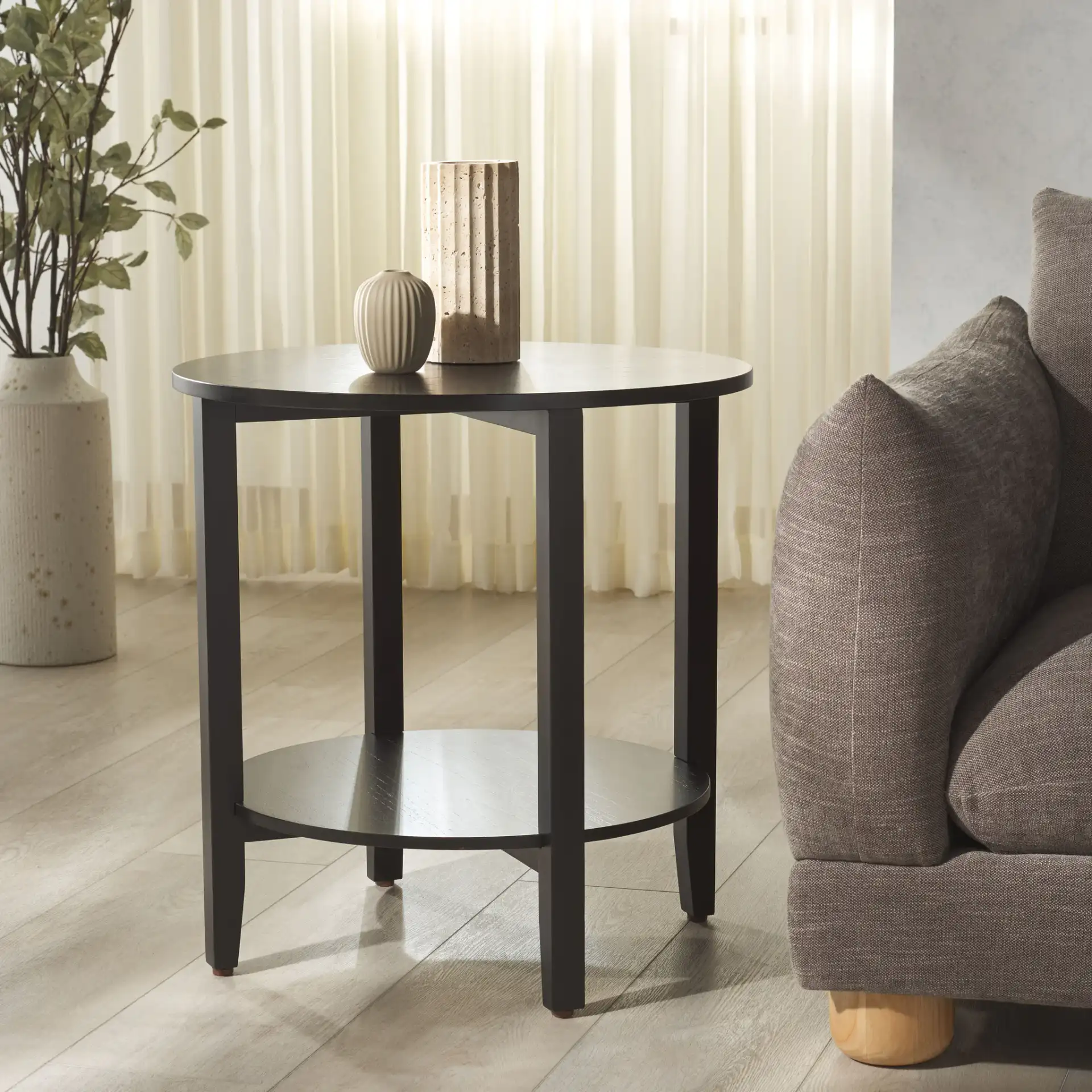 Leonardi Round Wood Accent Table in Black in a styled room
